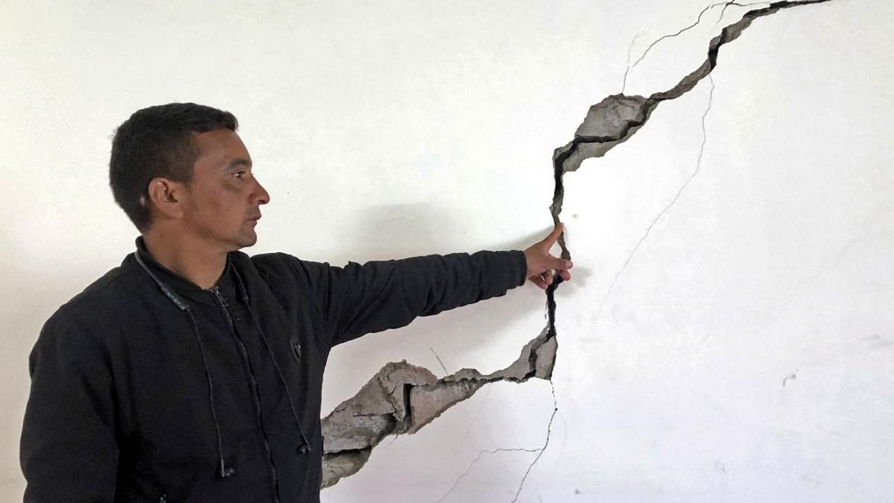A resident shows a crack on the wall of his house at Joshimath in Chamoli district of Uttarakhand. Credit: PTI Photo