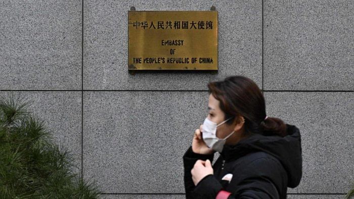 A pedestrian walks outside the Chinese embassy in Seoul. credit: AFP Photo