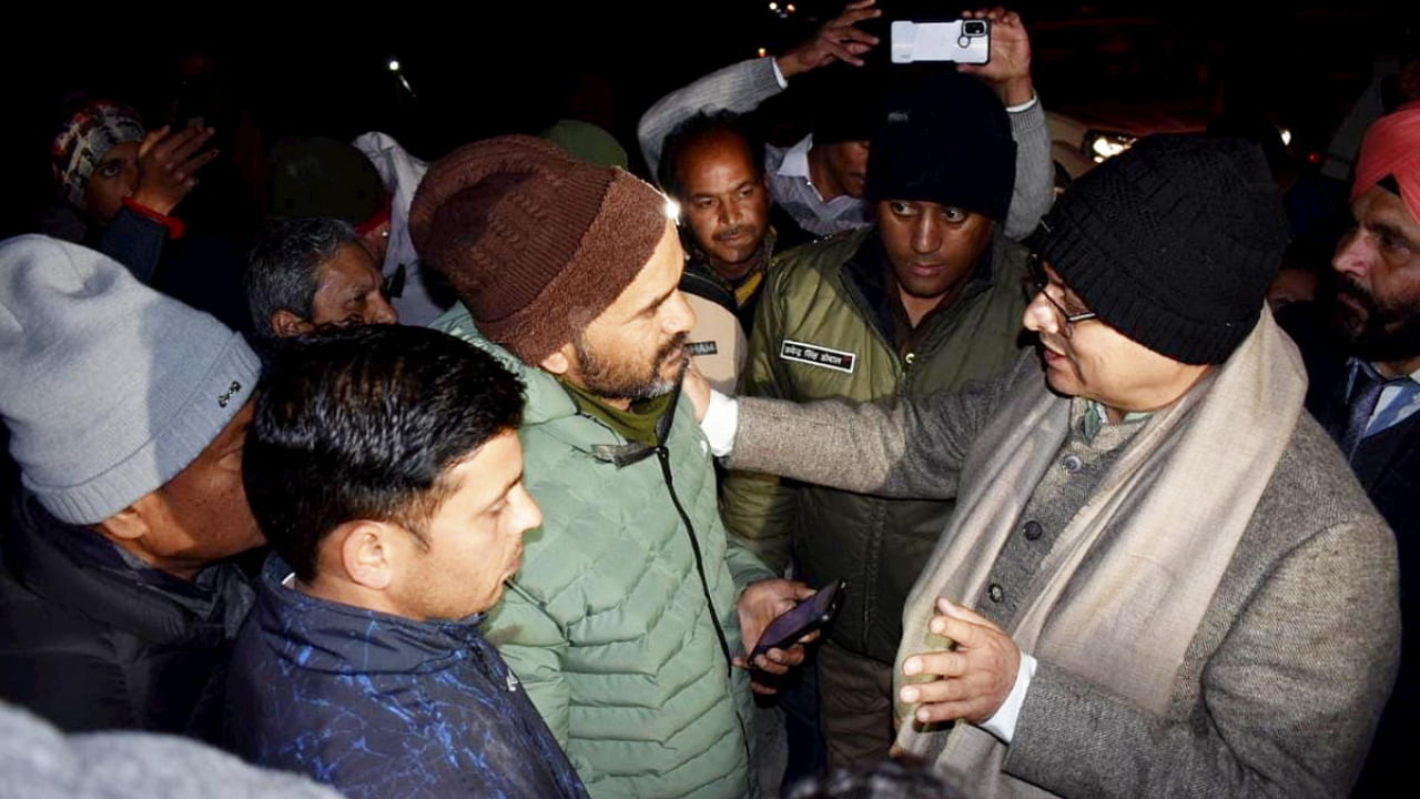 Dhami interacts with the residents of landslide affected area of Joshimath. Credit: PTI Photo