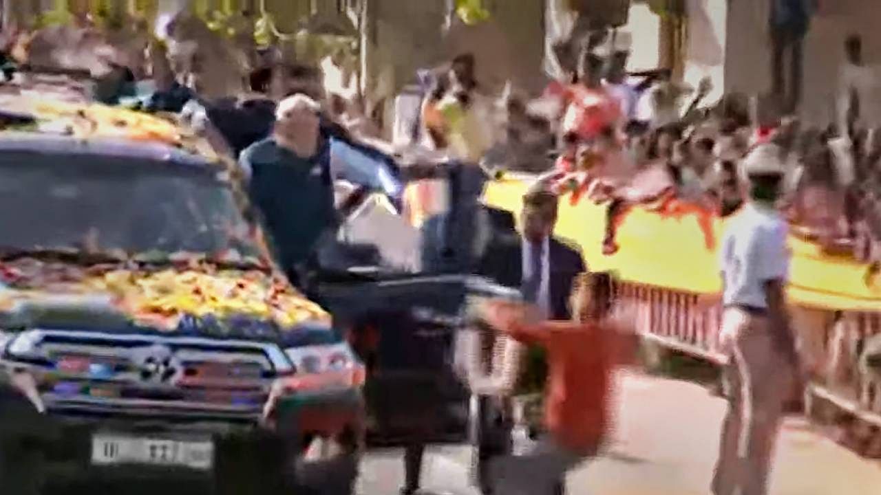 A youngster tries to hand a garland to Prime Minister Narendra Modi while allegedly breaching his security cover during his roadshow in Hubballi. Credit: PTI Photo