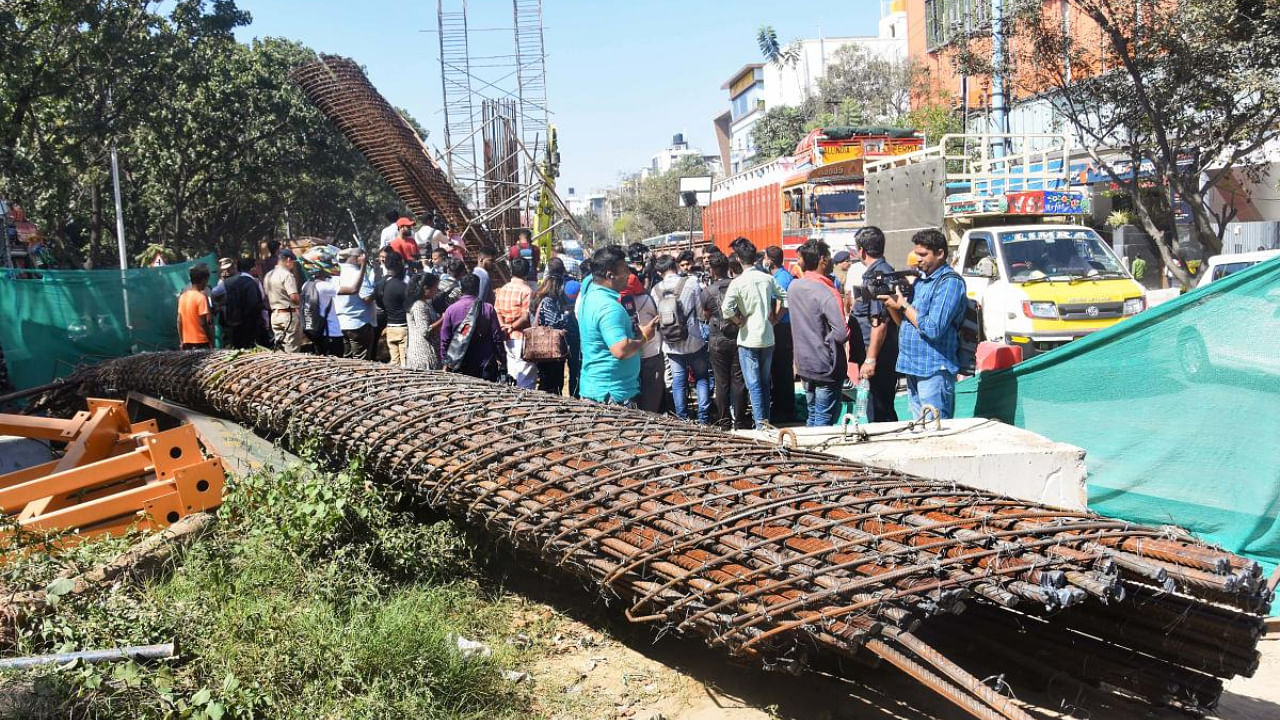  People gather at the accident site where a half broken iron structure of a metro pillar fell, at Hennur Main Road in Bengaluru. Credit: PTI Photo