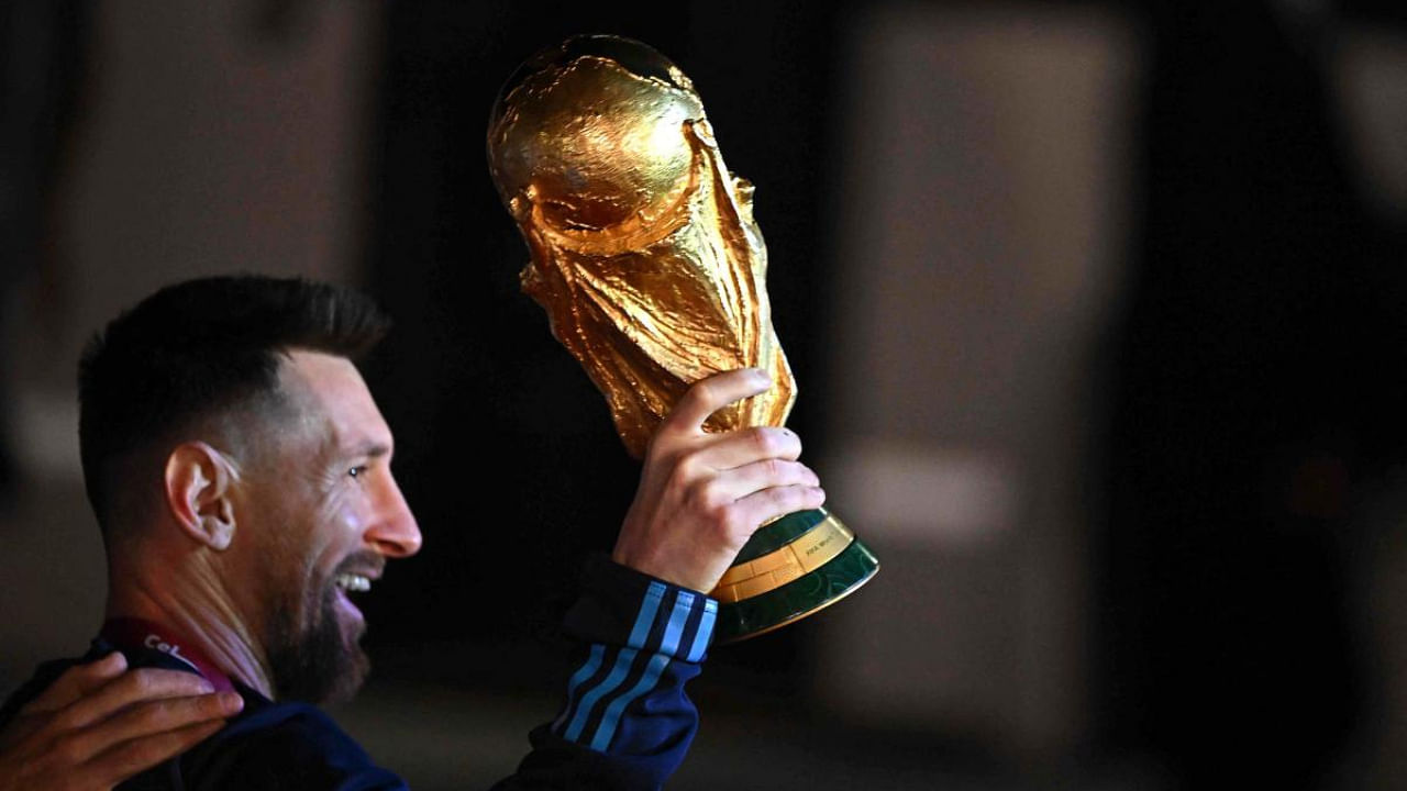  Argentina's captain and forward Lionel Messi holds the FIFA World Cup Trophy. Credit: AFP Photo