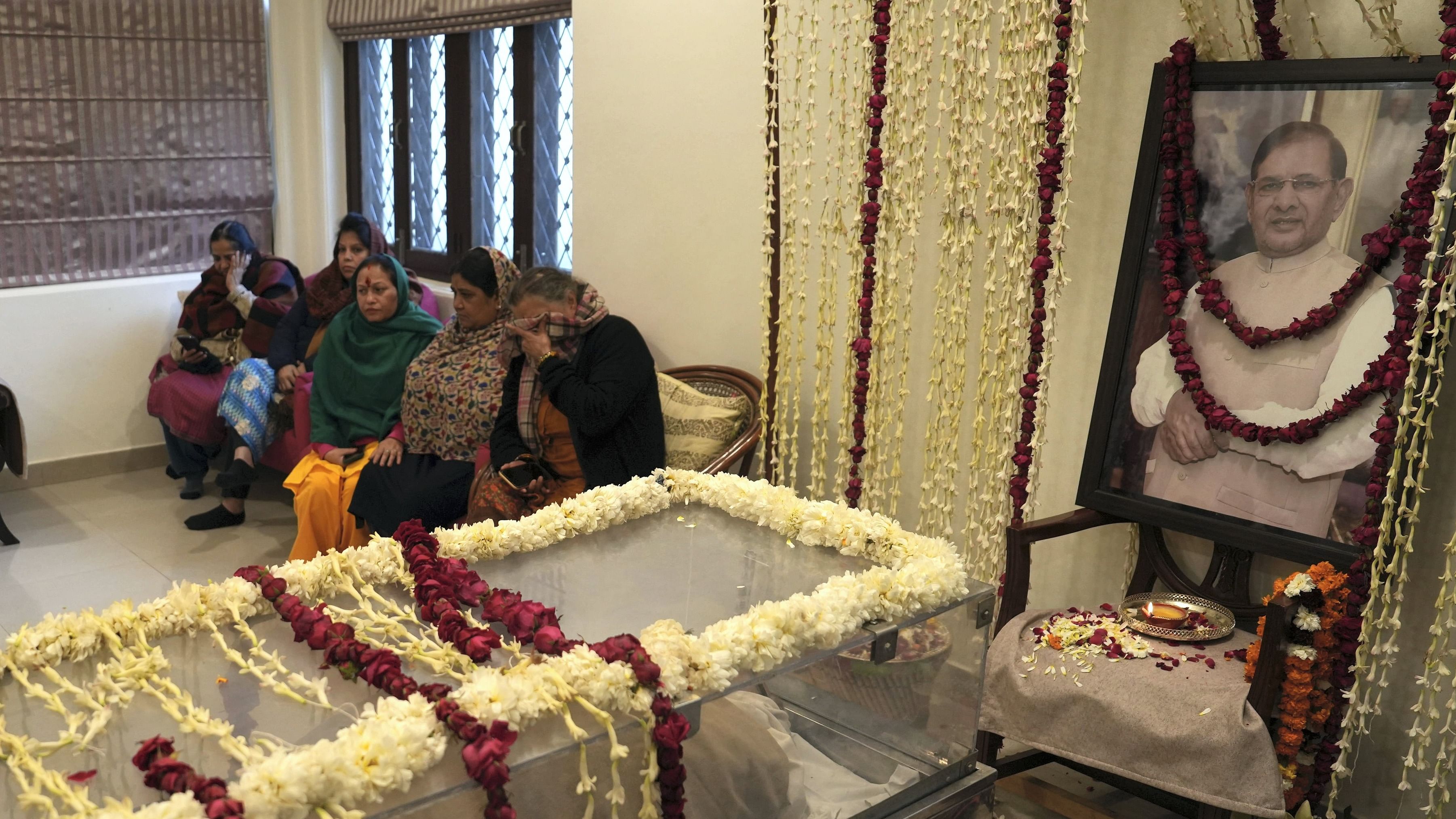 Family members and relatives of former union minister Sharad Yadav mourn near his mortal remains, at Chhatarpur in New Delhi. Credit: PTI Photo