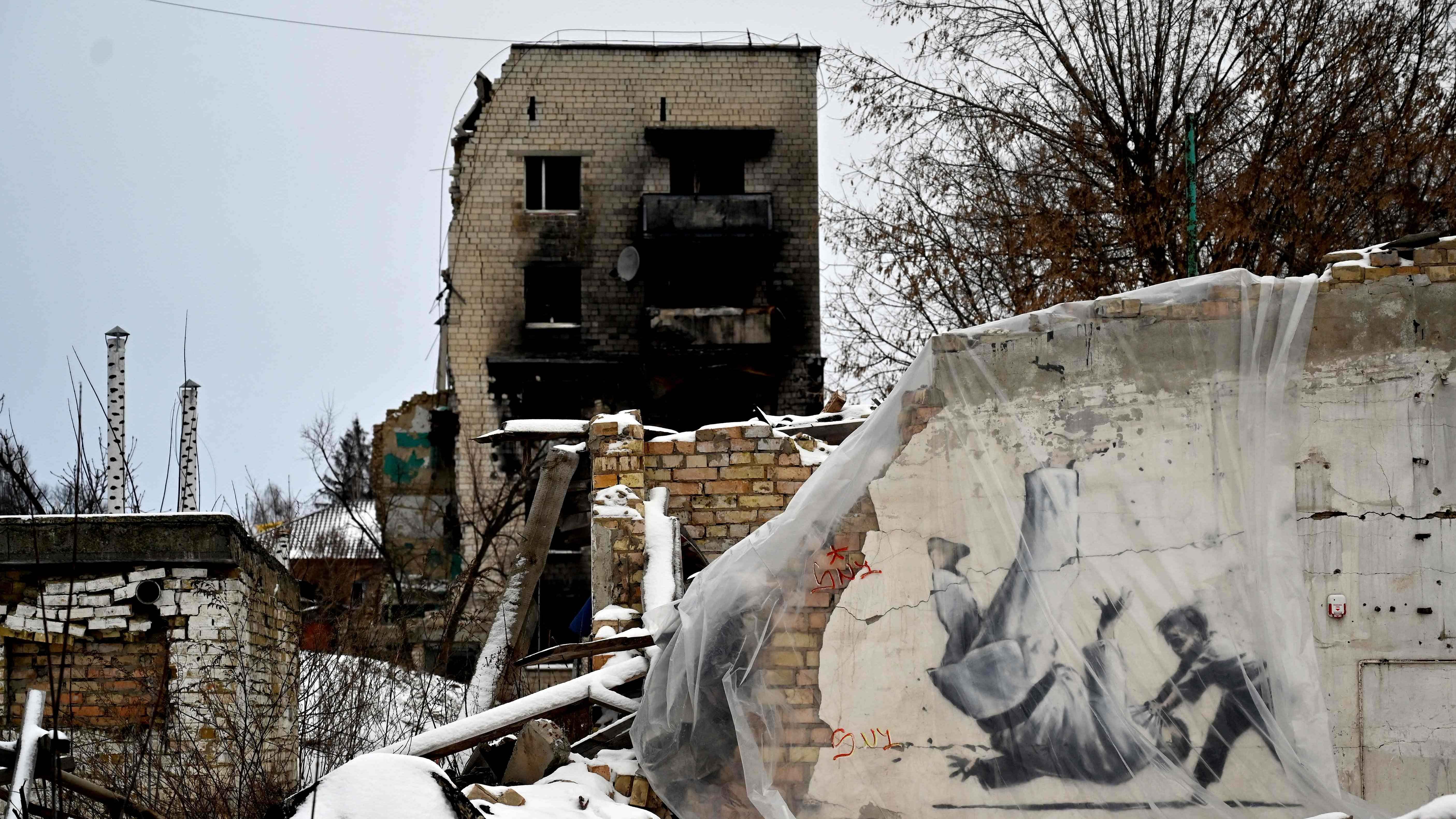  A photograph shows a piece by British street artist Banksy, covered with plastic, in the small Ukrainian town of Borodyanka, some 60 km from Ukrainian capital of Kyiv on January 12