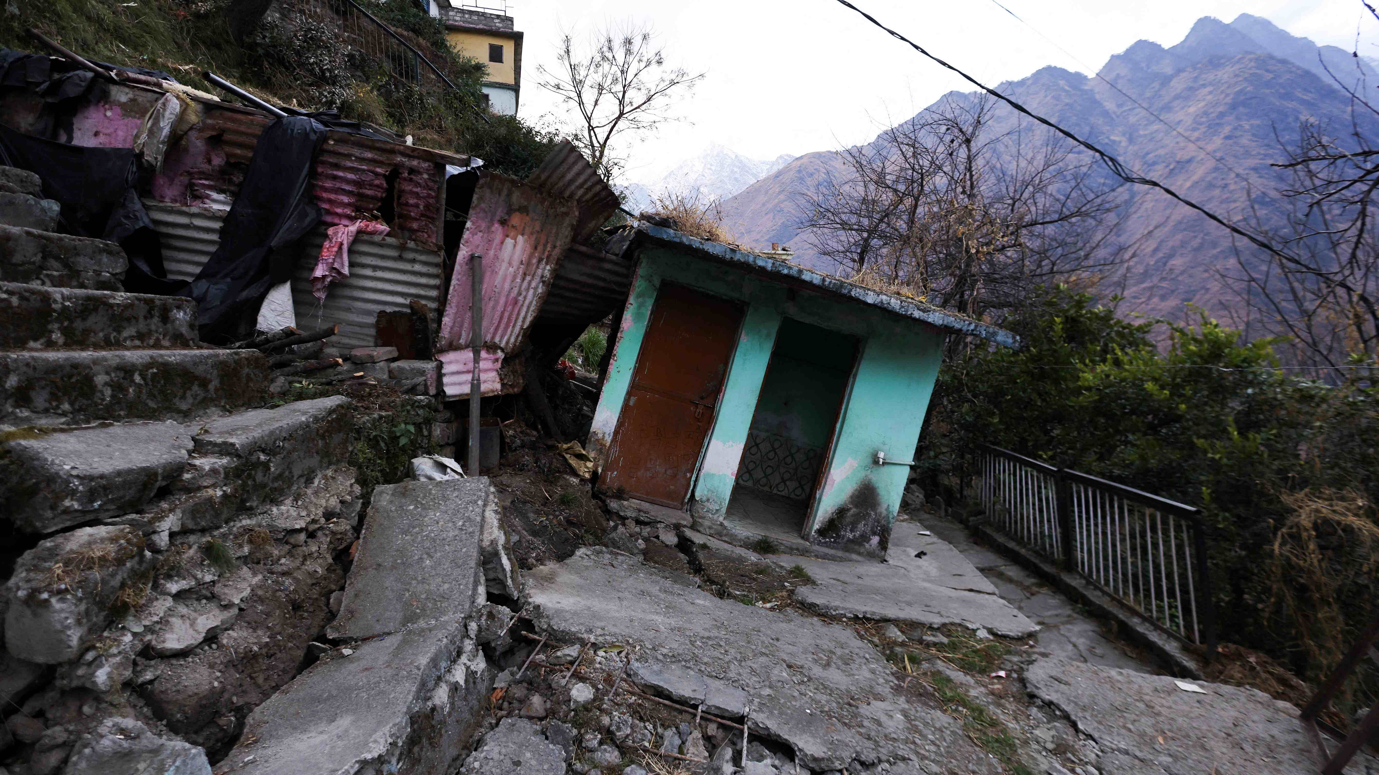 Cracks are seen on the stairs leading to a residential house and tilted rooms in Joshimath. Credit: Reuters Photo