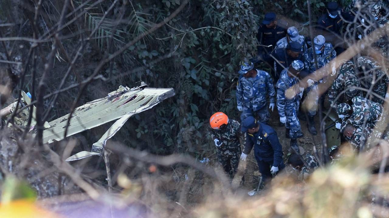Rescuers inspect the wreckage at the site of the plane crash in Pokhara. Credit: AFP Photo
