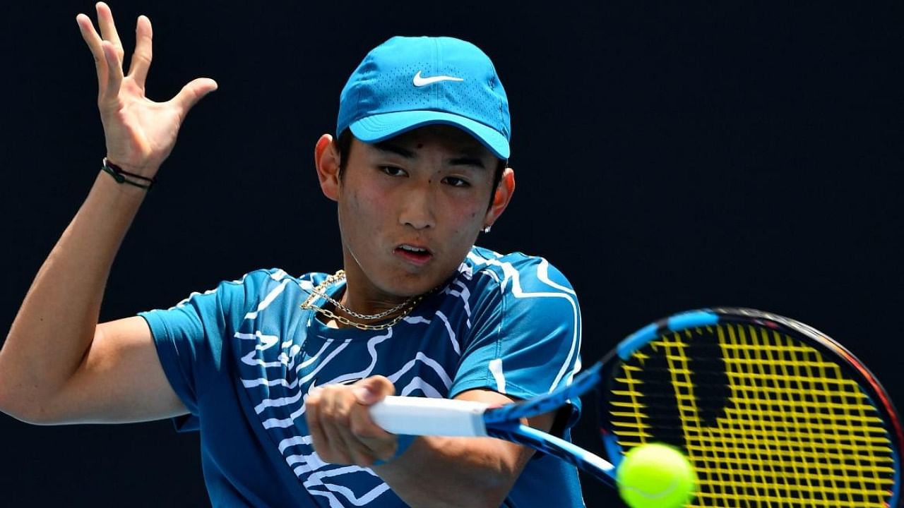 China's Shang Juncheng hits a return against Germany's Oscar Otte during their men's singles match on day one of the Australian Open tennis tournament in Melbourne. Credit: AFP