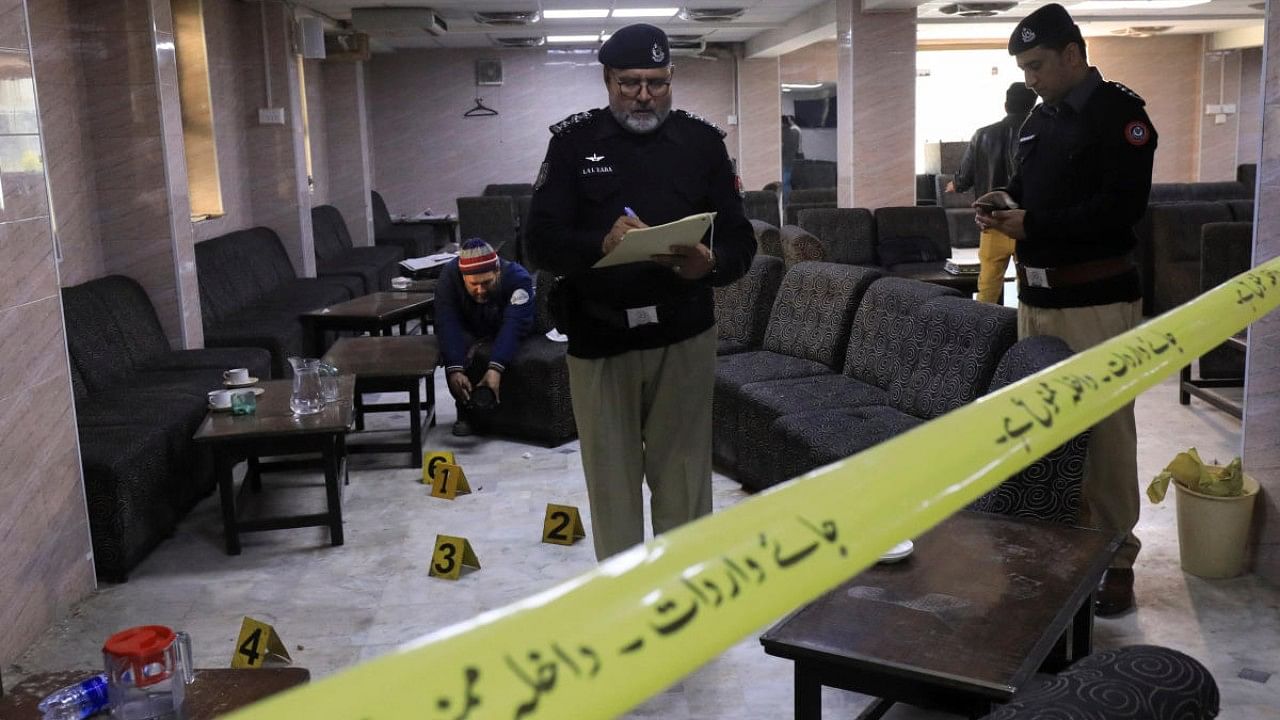 Police officers survey the crime scene after according to police, a gunman killed a lawyer in Peshawar. Credit: Reuters Photo