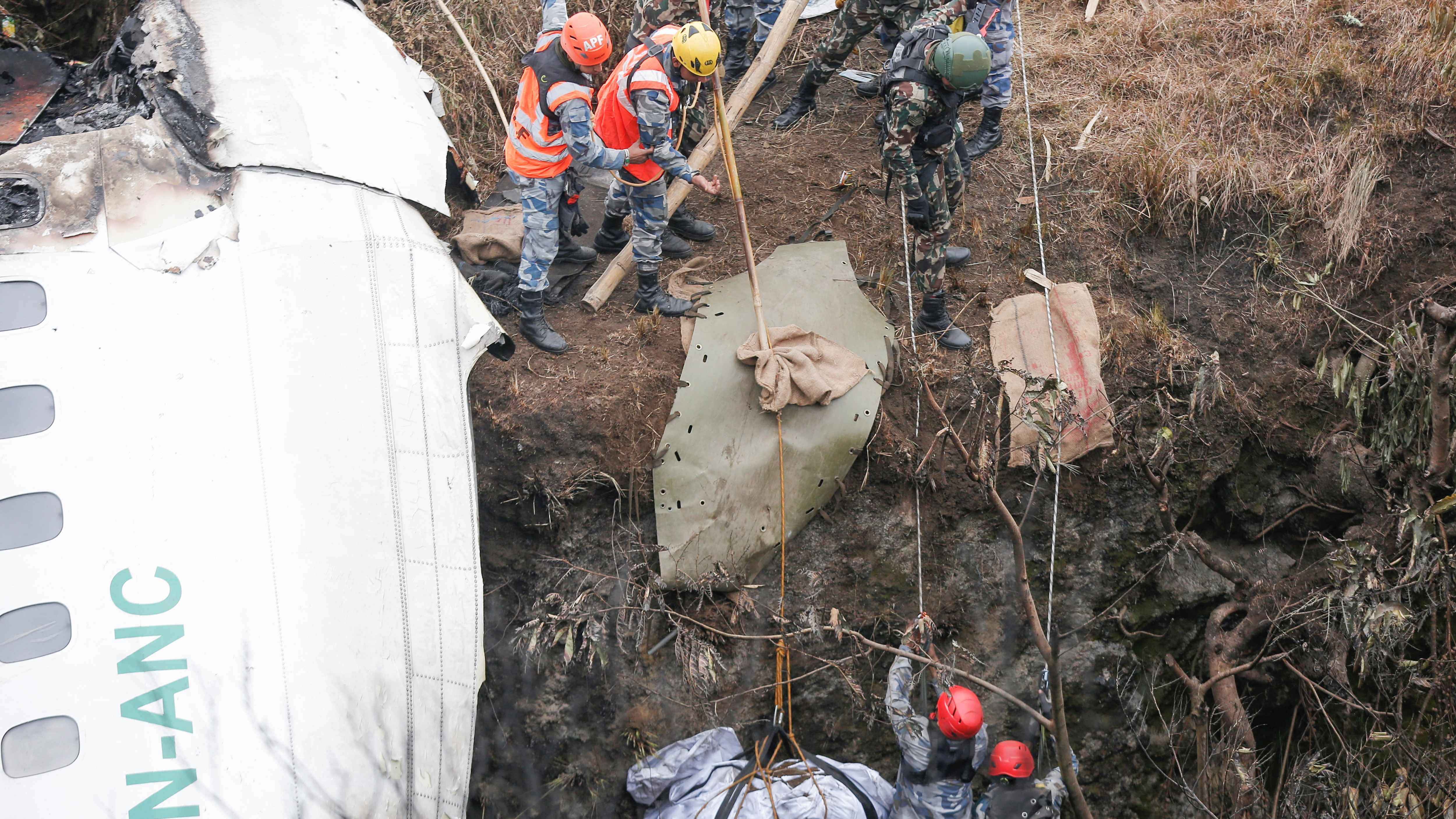 A rescue team recovers the body of a victim from the site of the plane crash. Credit: Reuters Photo