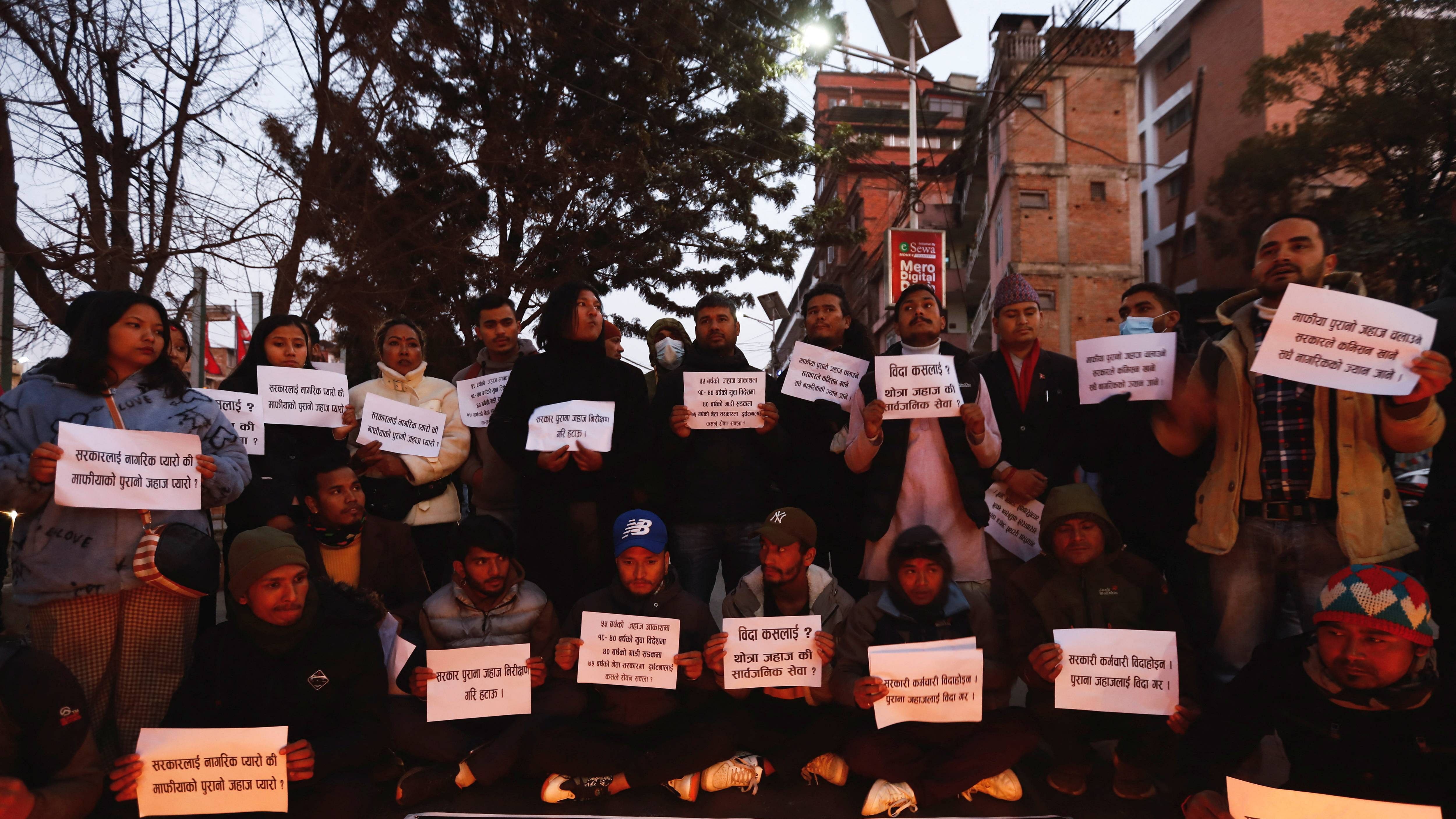 People holding placards take part in a condolence and protest meeting following the plane crash. Credit: Reuters Photo