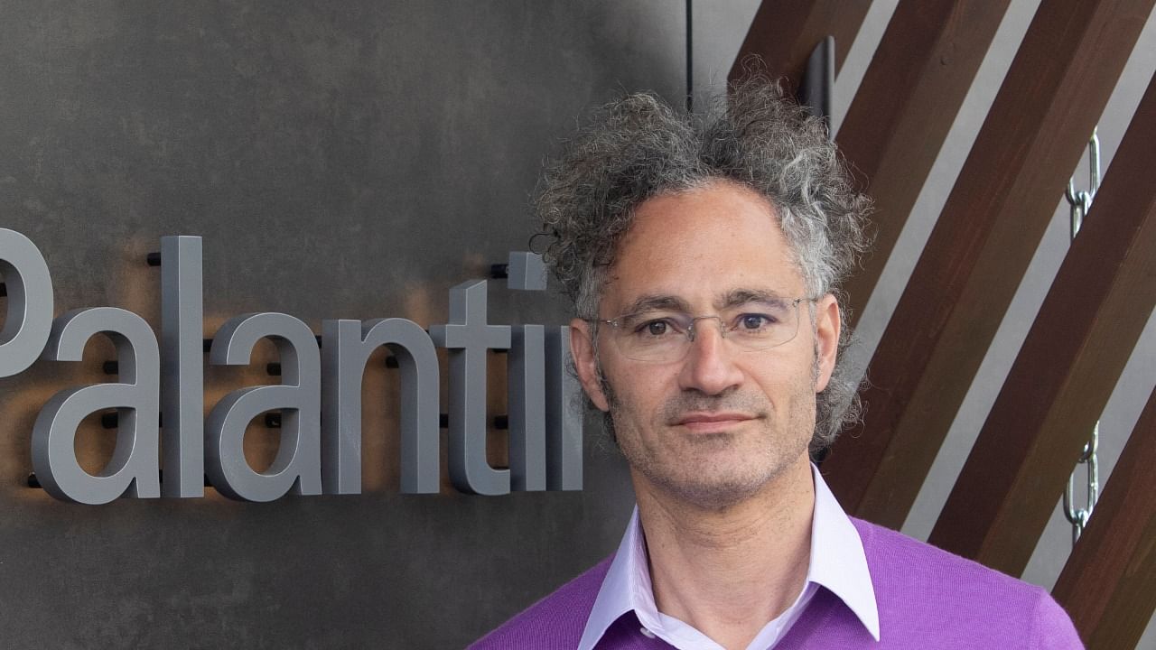 Alex Karp, CEO of Palantir Technologies poses beside the company's logo ahead of an interview with Reuters in the Alpine resort of Davos. Credit: Reuters photo