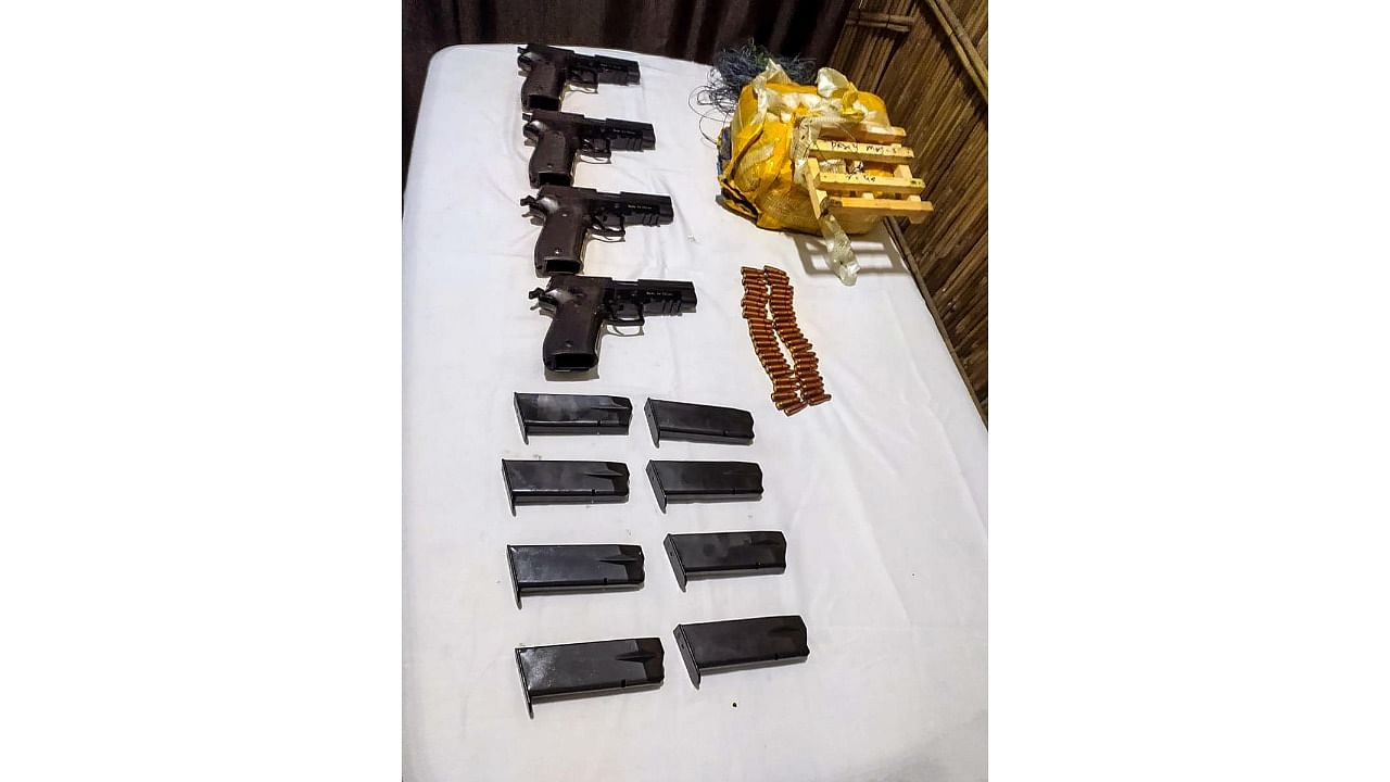 Border Security Force (BSF) personnel display arms, ammunition and magazines recovered after being dropped by a drone along the international border, in Gurdaspur district, Punjab. Credit: PTI Photo