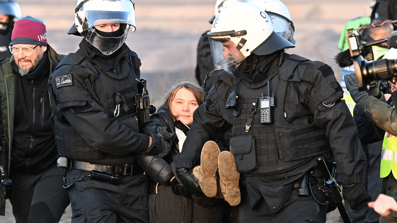 Police officers carry Swedish climate activist Greta Thunberg (C) out of a group of demonstrators and activists in Erkelenz, western Germany. Credit: AFP Photo