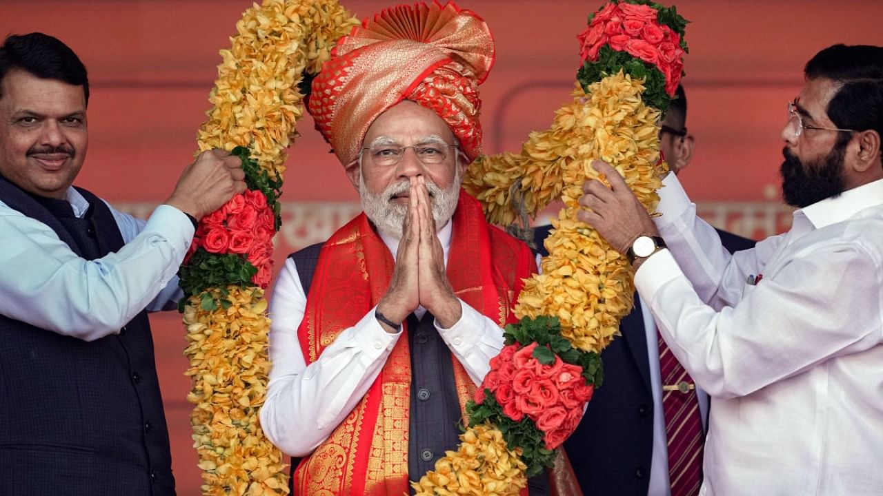 Prime Minister Narendra Modi being garlanded by Maharashtra Chief Minister Eknath Shinde and Deputy Chief Minister Devendra Fadnavis. Credit: PTI Photo