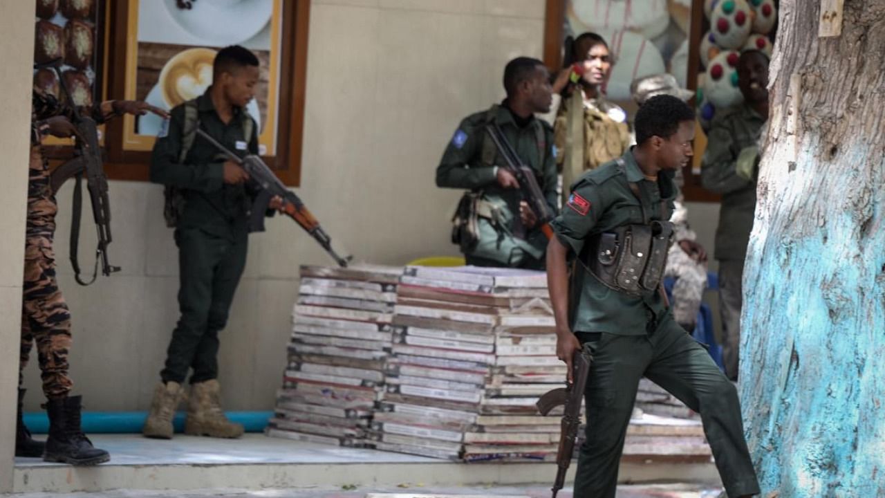 Police officers take up positions outside of the Mayor's office where an ongoing gun battle erupted following a reported explosion, in Mogadishu. Credit: AFP Photo