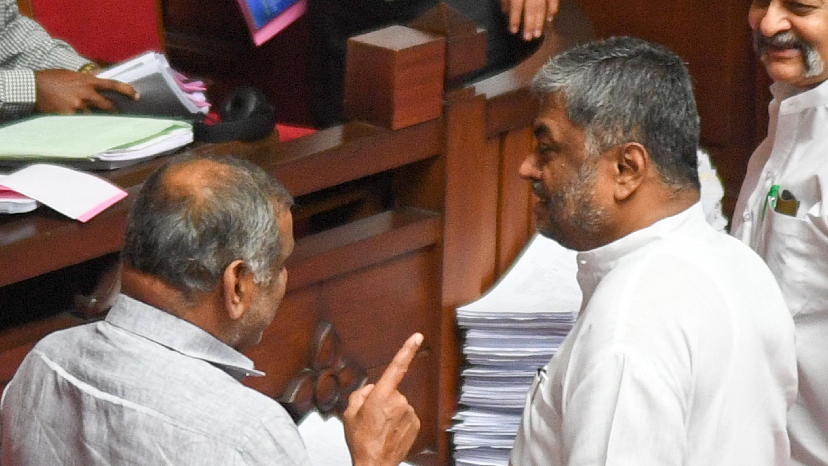 J C Madhuswamy, Minister of Law, Parliamentary affairs and Legislation interacting with Council Opposition leader B K Hariprasad, during the lunch break Council session in Vidhana Soudha, in Bengaluru on Wednesday. Credit: DH Photo
