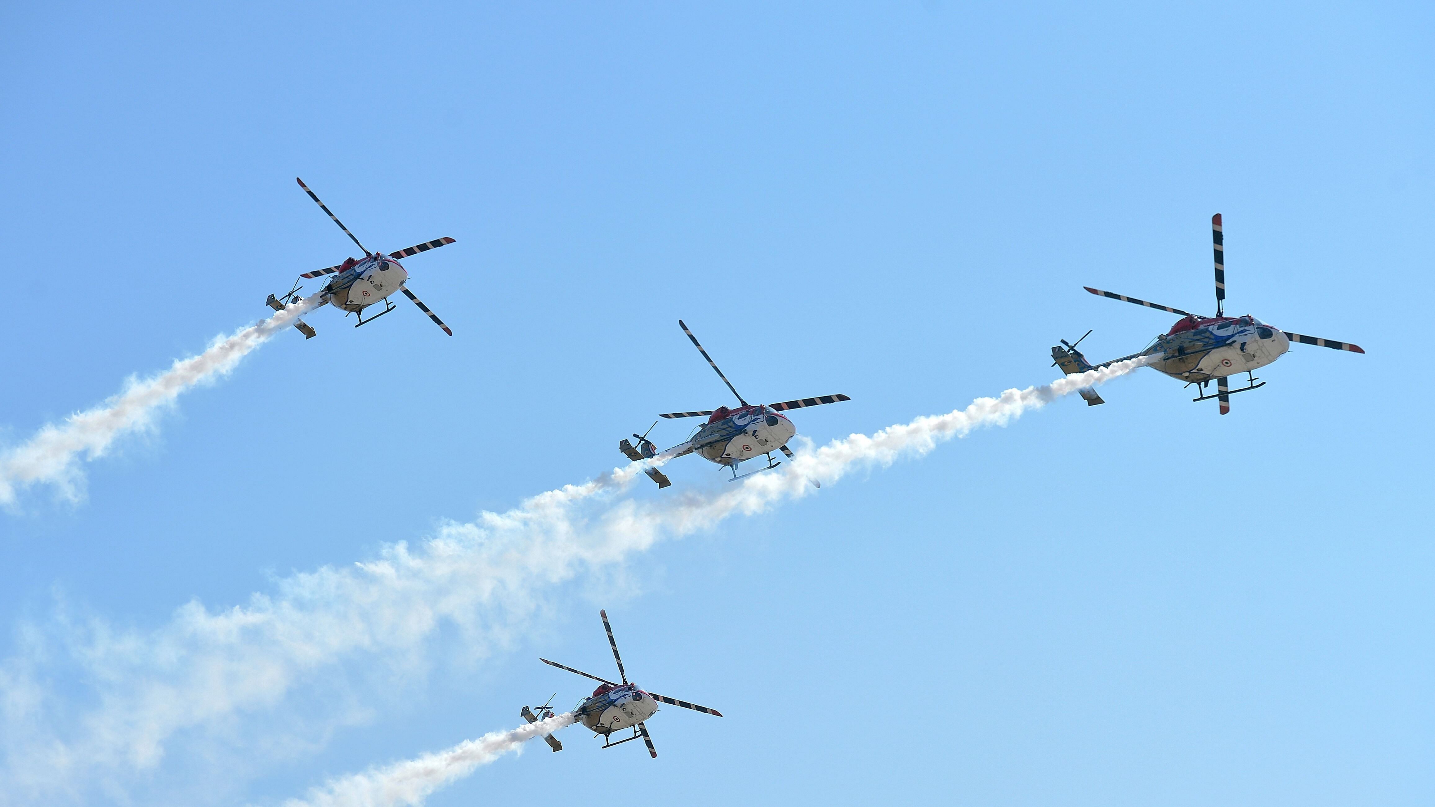 Indian Air Force Sarang team fly the Dhruv Advanced Light Helicopters during the inaugural day of the five-day Aero India 2019 airshow at the Yelahanka Air Force station, in Bangalore on February 20, 2019. - The Aero India 2019 airshow starts on February 20 and ends on February 24. Credit: AFP Photo