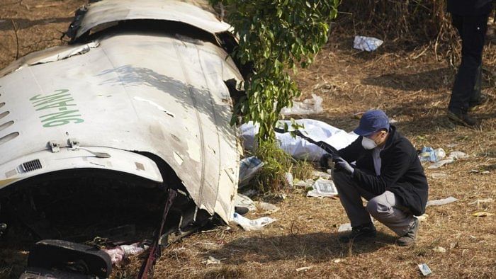 Officials examine the crashed parts of the Nepal flight. Credit: PTI File Photo