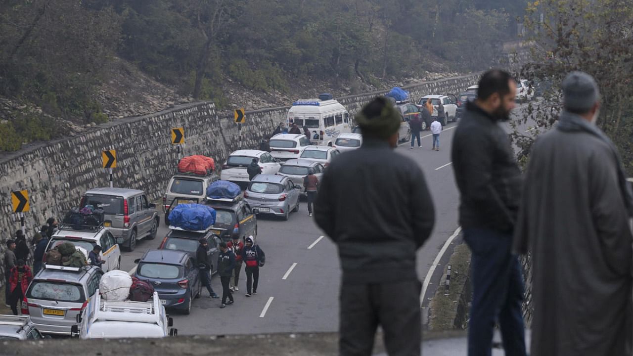 Srinagar-bound vehicles line up on a road as Jammu-Srinagar National Highway remains closed for vehicular traffic following heavy snowfall, at Nagrota in Jammu, Saturday, Jan. 14, 2023. Credit: PTI Photo