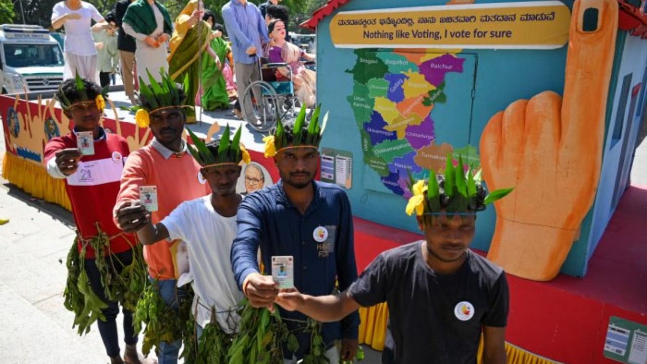 First-time voters pose with their voter ID cards during the 13th National Voters' Day celebration at Town Hall in Bengaluru on Wednesday. Credit: DH Photo