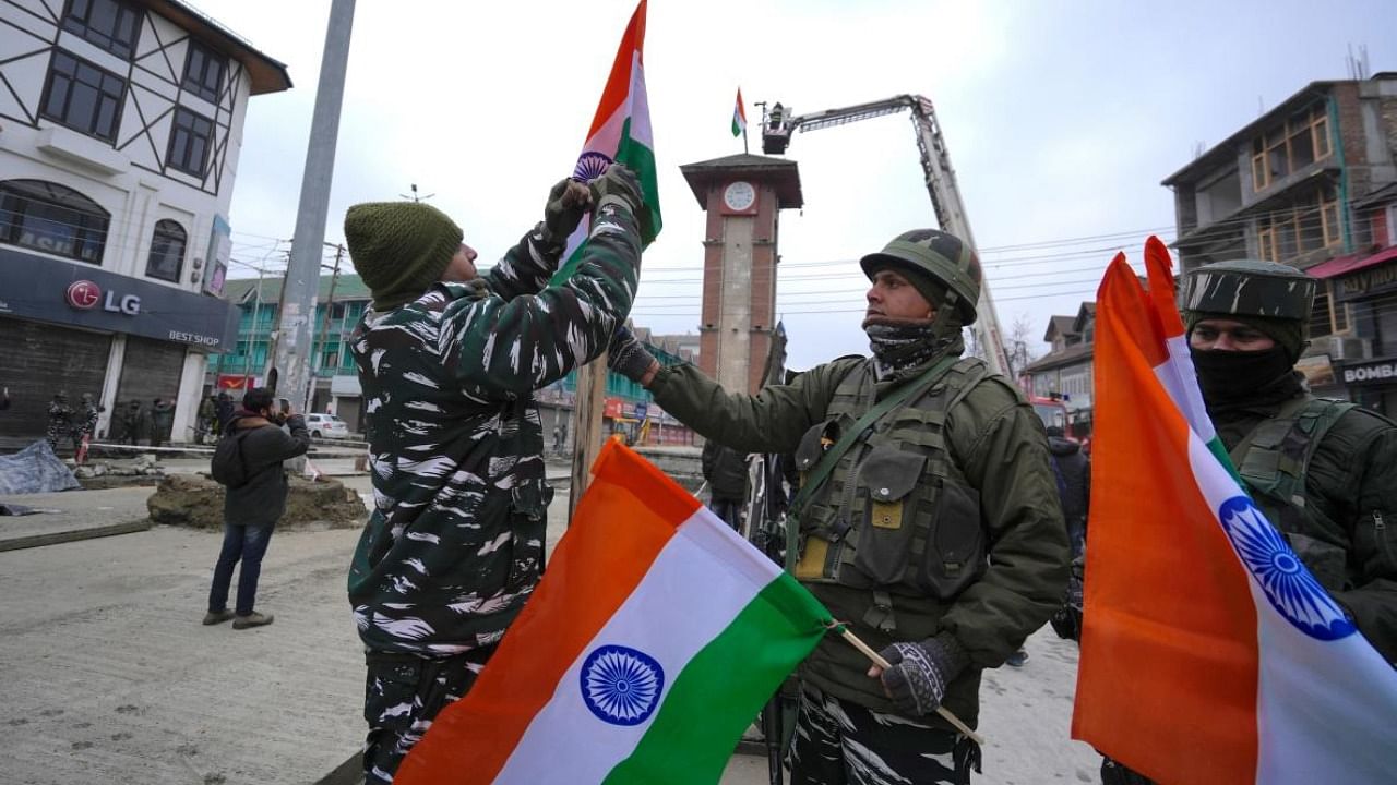 CRPF personnel hoist national flag on the occasion of the 74th Republic Day, at Lal Chowk in Srinagar. Credit: PTI Photo