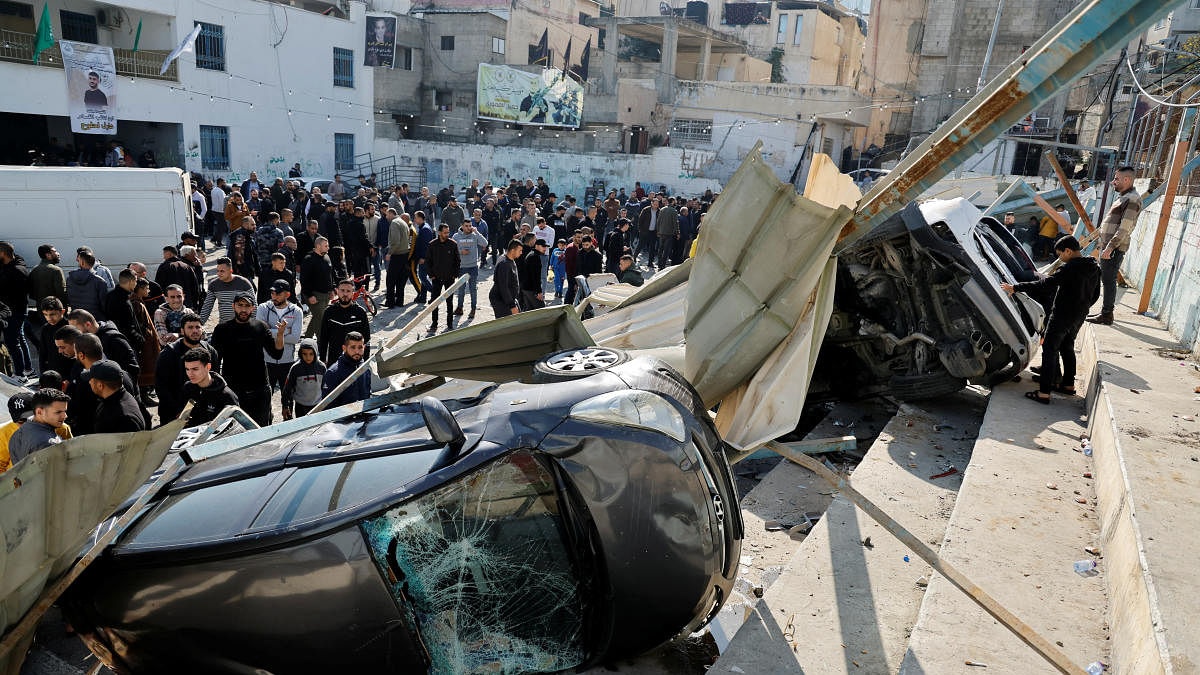 Palestinians inspect damaged vehicles following an Israeli raid in Jenin in the Israeli-occupied West Bank. Credit: Reuters Photo