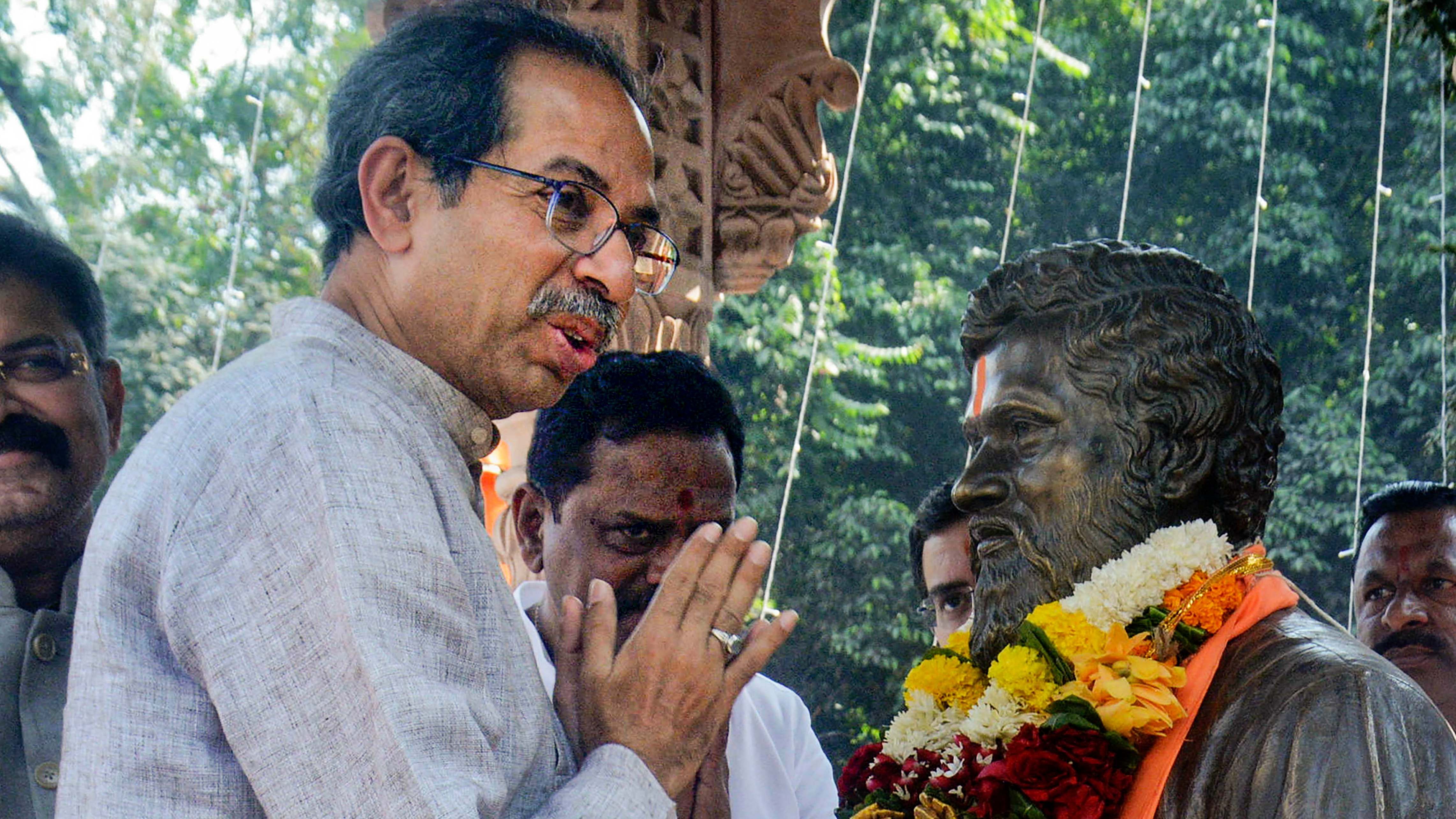Uddhav Thackeray pays tribute to the bust of party leader Anand Dighe on Republic Day. Credit: PTI Photo
