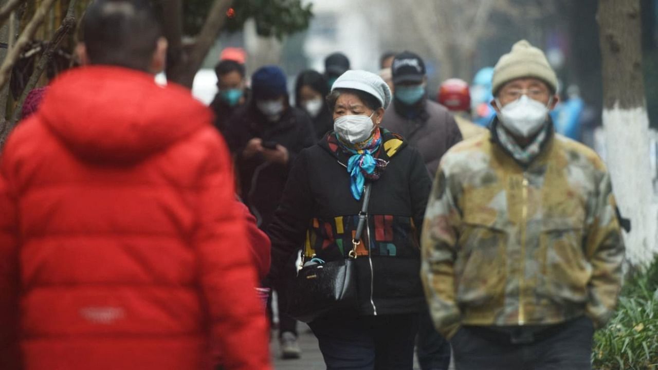 Residents walk along a street in Hangzhou, in China's eastern Zhejiang province on January 17, 2023. Credit: AFP Photo