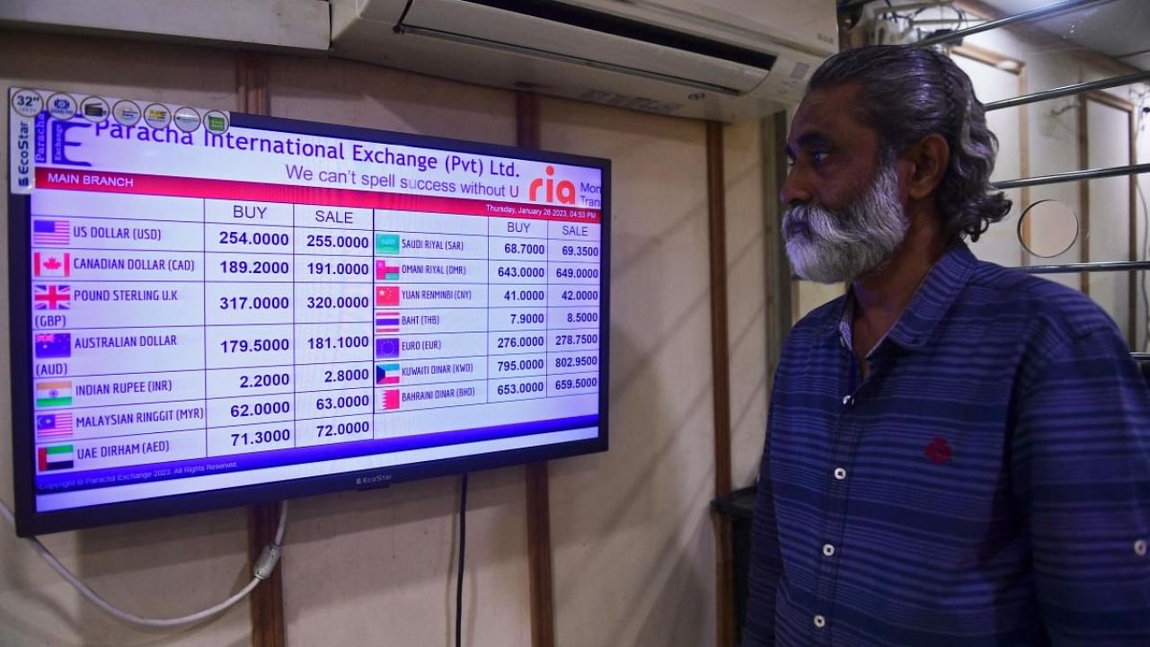 A customer checks foreign currency rates displayed on a monitor at a money exchange market in Karachi on January 26, 2023. Credit: AFP Photo