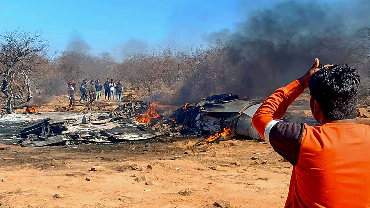 Locals near the wreckage of planes after a Su-30MKI and a Mirage 2000 fighter planes crashed during an exercise. Credit: PTI Photo