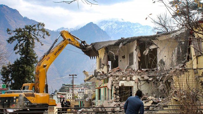 <div class="paragraphs"><p>Workers  demolish PWD guest house which has been marked unsafe at a land subsidence affected area, in Joshimath.  </p></div>