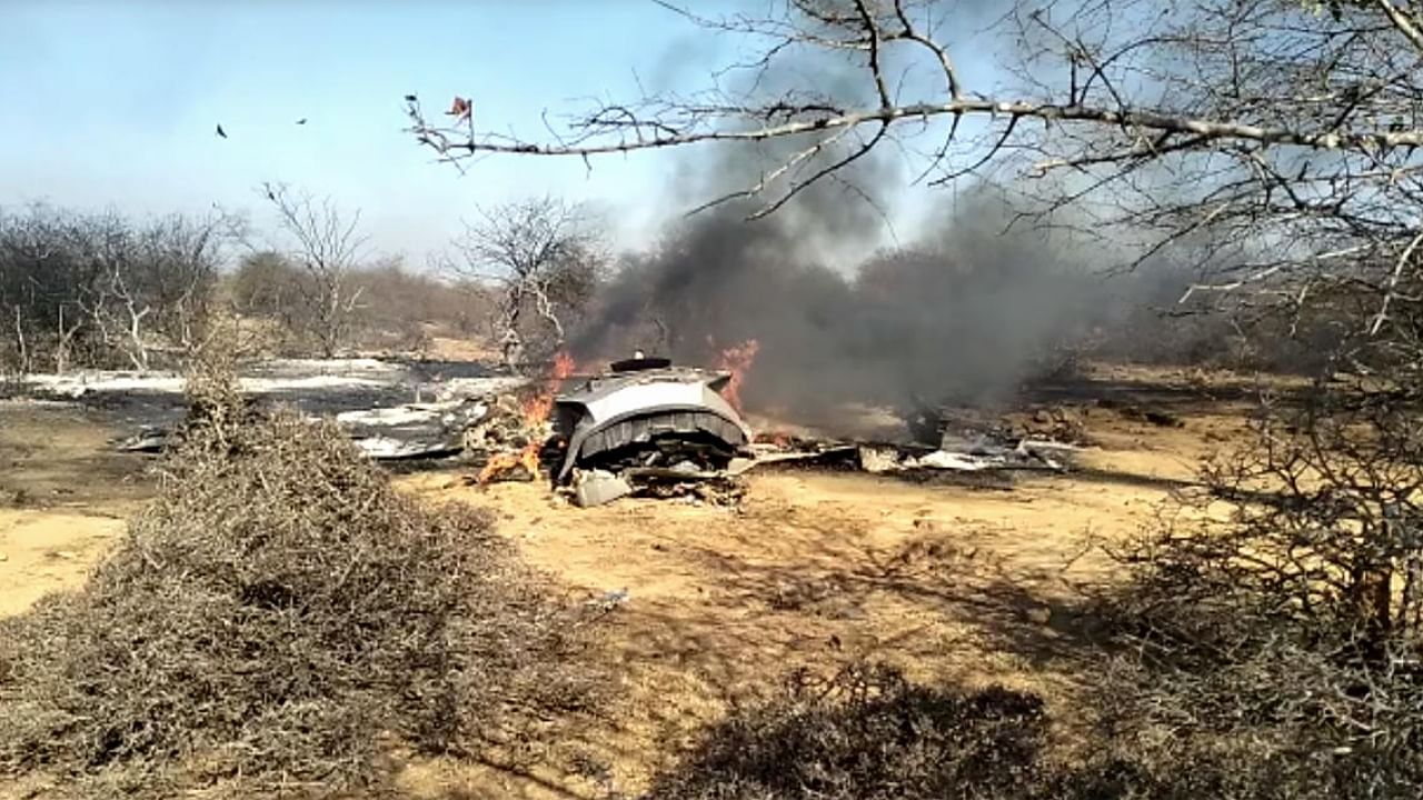 Security personnel near the wreckage after a Su-30MKI and a Mirage 2000 fighter planes crashed during an exercise, at Pagadgarh in Morena district. Credit: PTI Photo