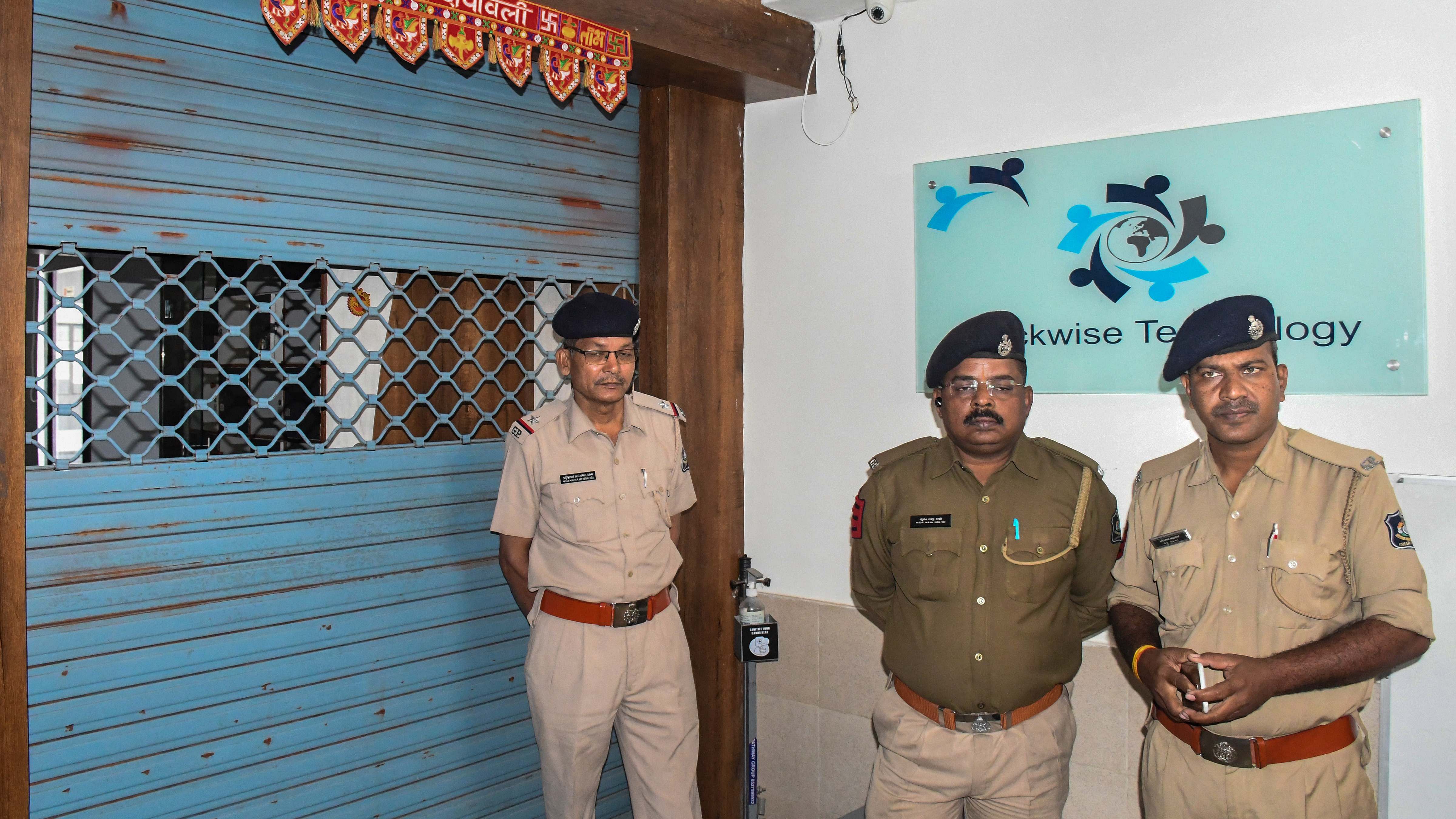 Police personnel stand outside the coaching centre where Junior Clerk's examination paper allegedly got leaked. Credit: PTI Photo
