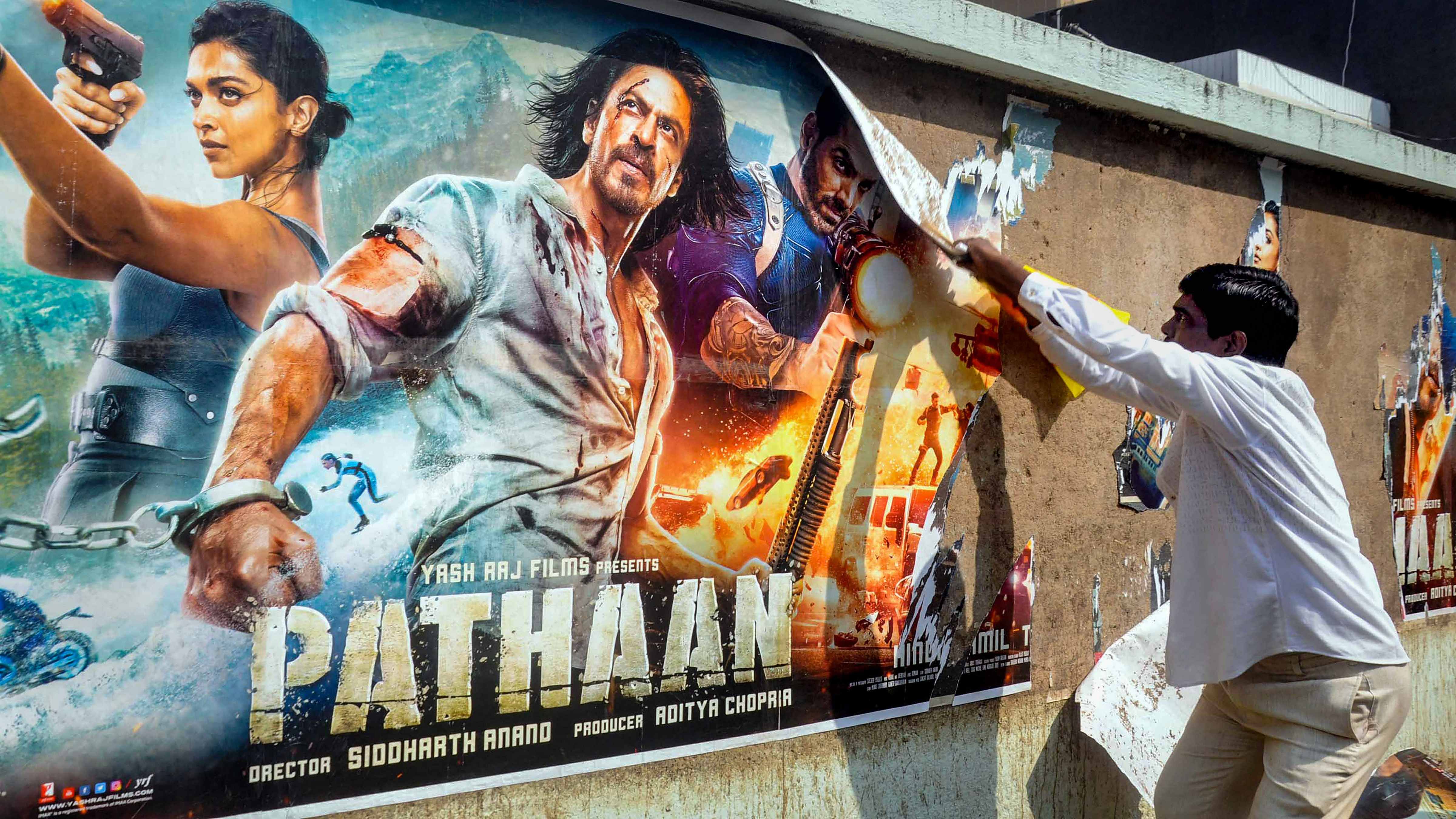 Members of Kalinga Sena tear posters of the newly-released movie 'Pathaan' during a protest, in Bhubaneswar. Credit: PTI Photo