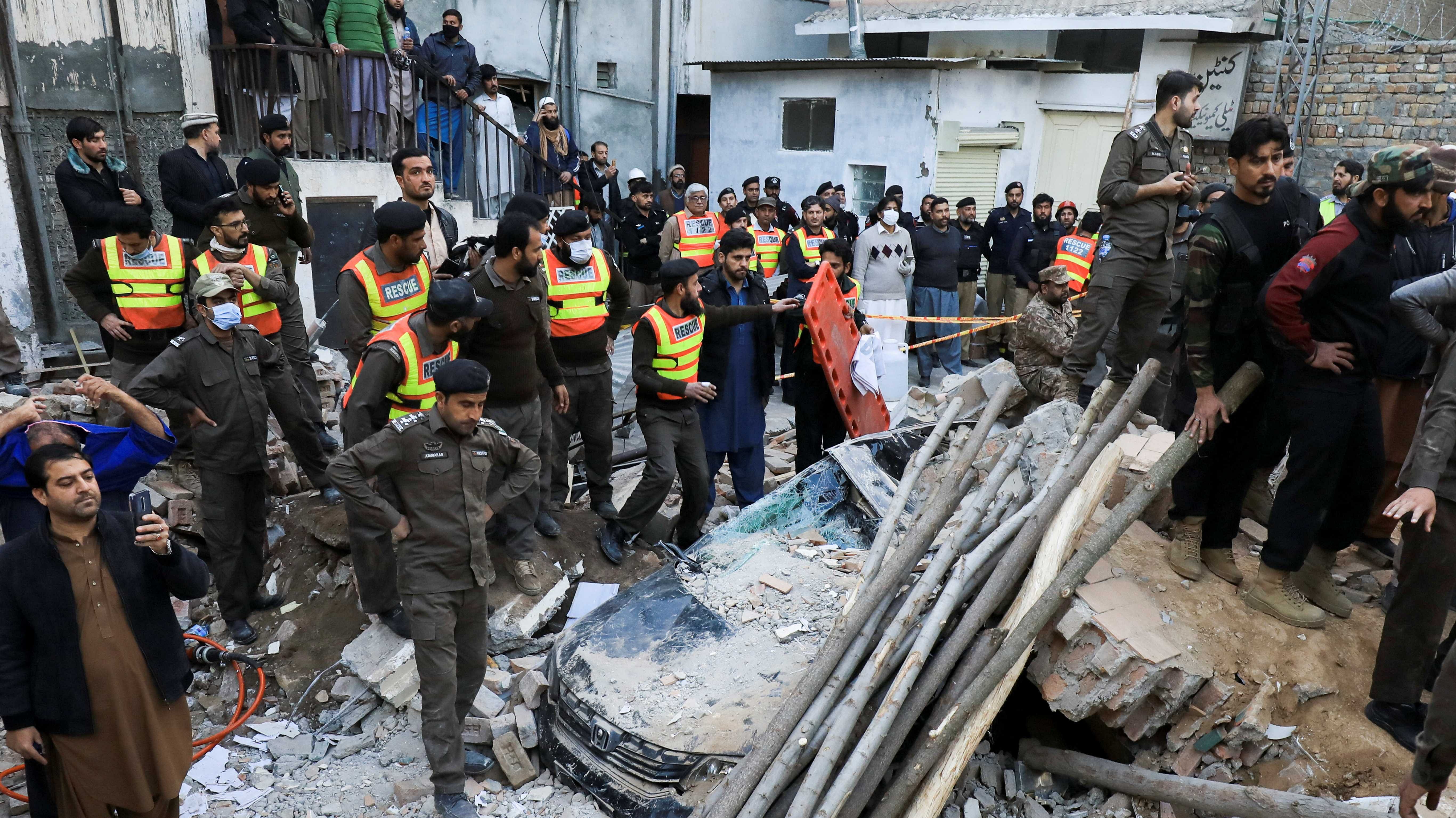 People and rescue workers gather amid the damages, after a suicide blast in a mosque in Peshawar. Credit: AFP Photo