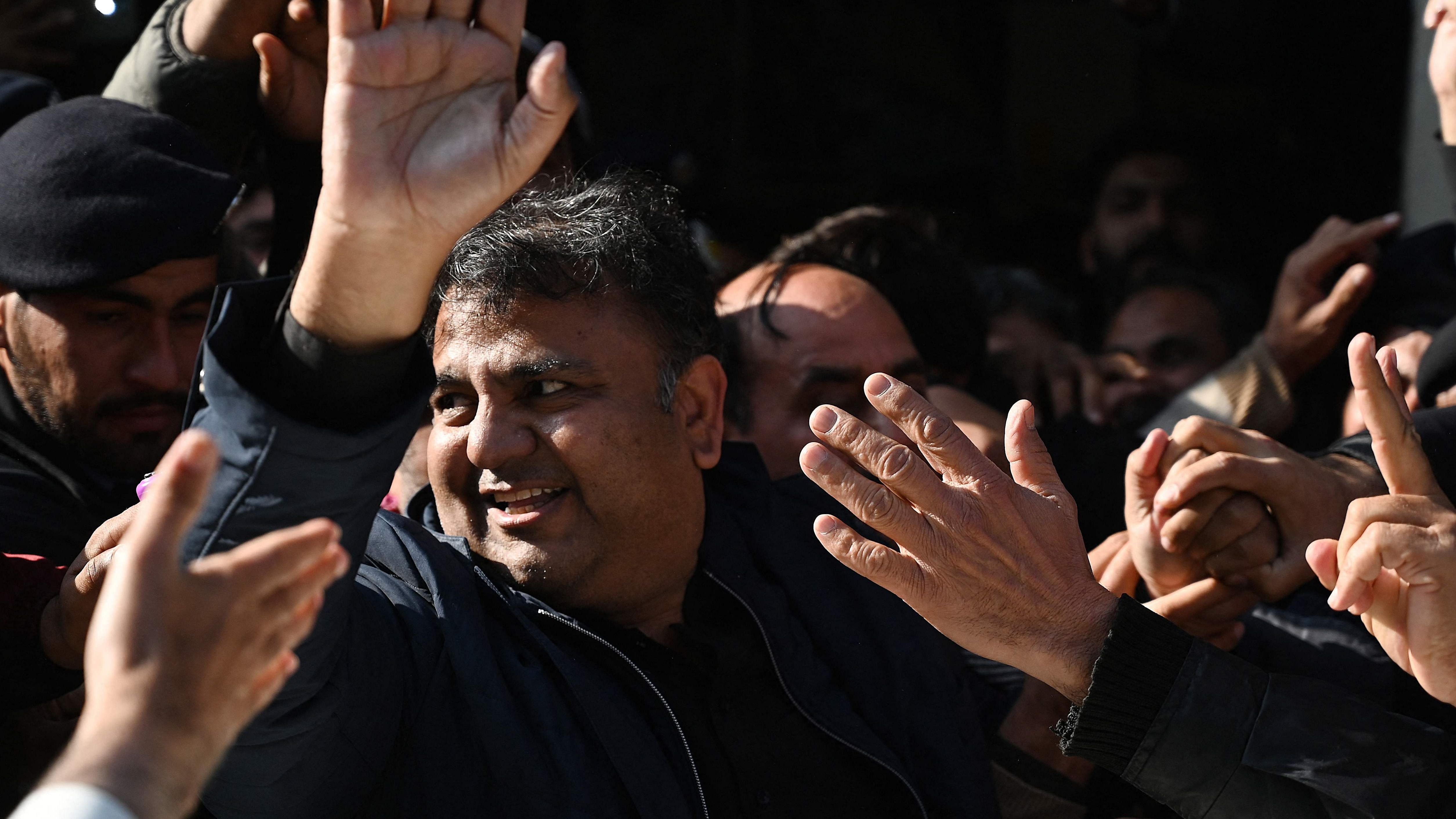 Pakistan's former information minister Fawad Chaudhry (C) gestures as police officials escort him after a hearing at a court in Islamabad. Credit: AFP Photo