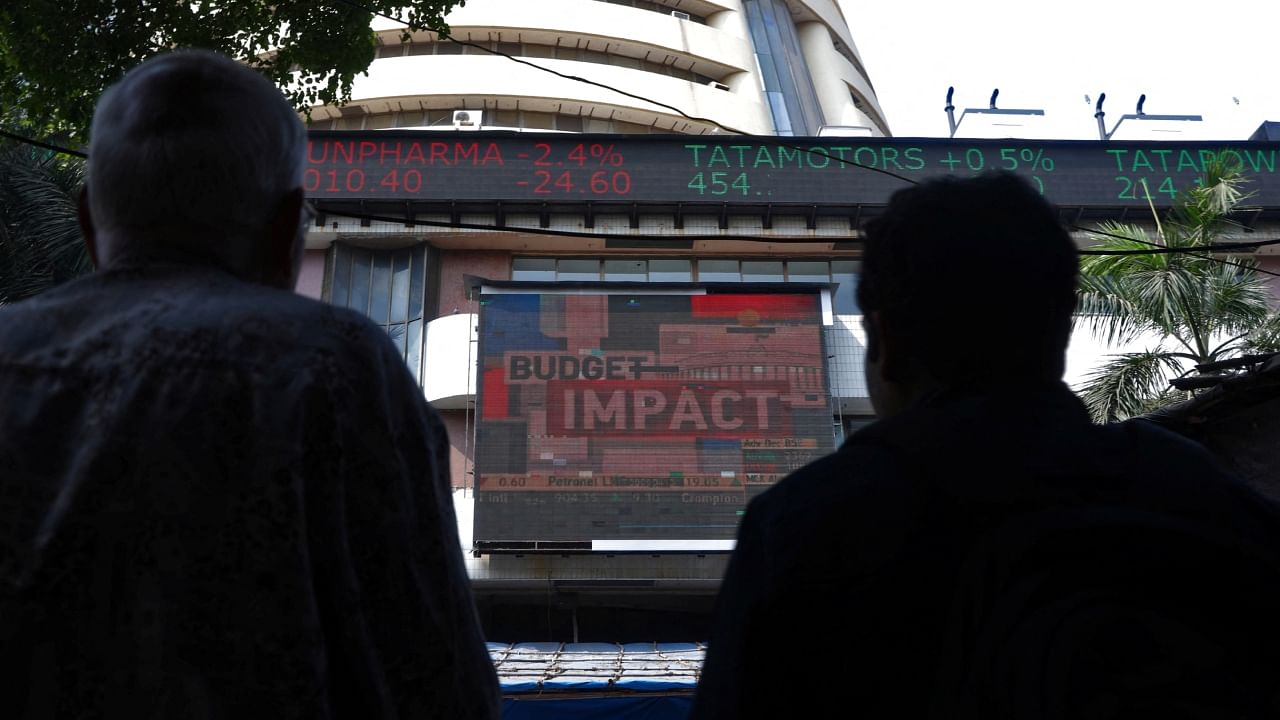 Men watch a screen displaying the Sensex results on the facade of the Bombay Stock Exchange (BSE) building in Mumbai, February 1, 2023. Credit: Reuters Photo