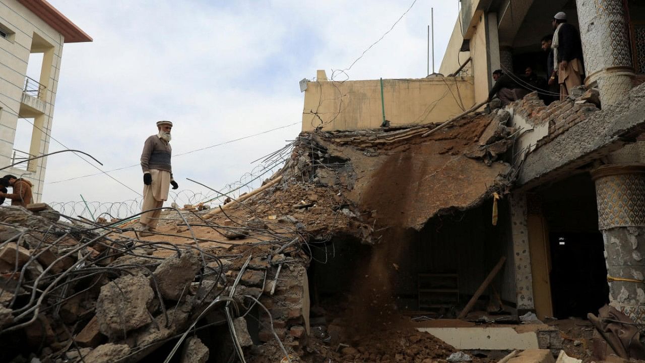 Man stands amid a damaged structure, days after a suicide blast in a mosque in Peshawar. Credit: Reuters Photo