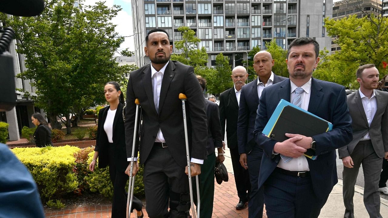 Australian tennis player Nick Kyrgios (2nd L) arrives on crutches to the magistrate's court in Canberra on February 3, 2023. - Kyrgios will try to have an assault charge against him dismissed on mental health grounds.  Credit: AFP Photo