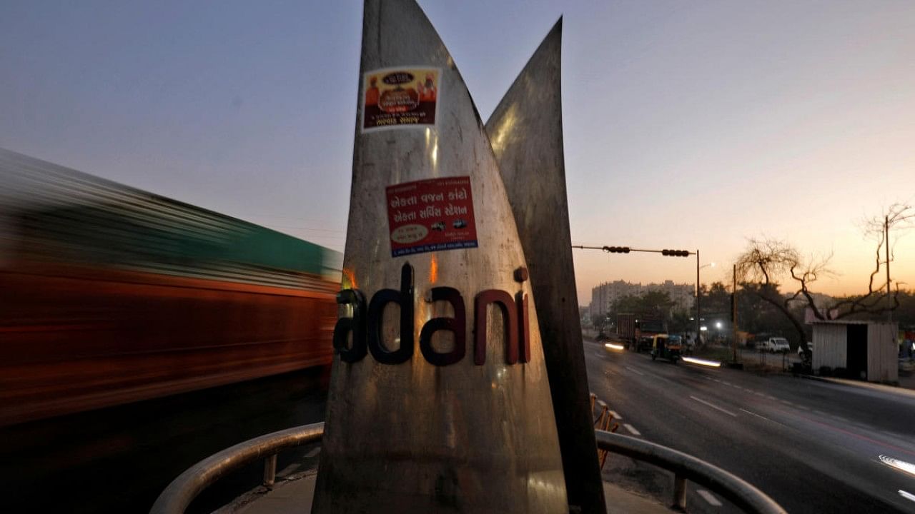 Traffic moves past the logo of the Adani Group installed at a roundabout on the ring road in Ahmedabad. Credit: Reuters Photo