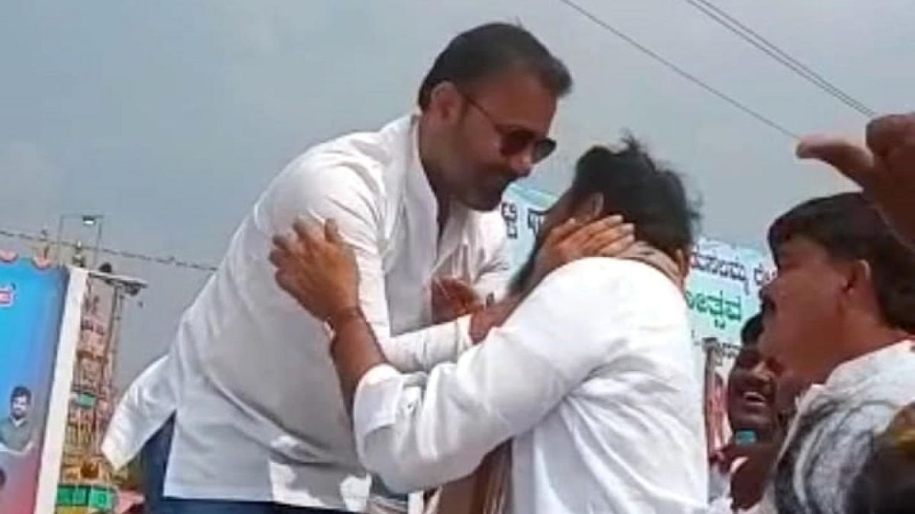 Minister B Sriramulu and Congress leader Santosh Lad hug each other and exchange pleasantries when their paths crossed at a religious function in Sandur taluk of Ballari district on Thursday. Credit: DH Photo