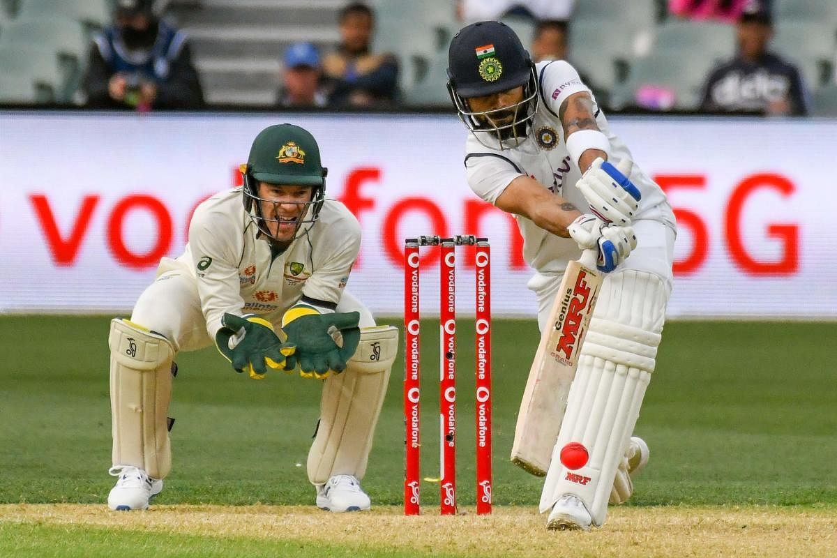 Virat Kohli plays a defensive shot as Australian wicketkeeper Tim Paine looks on during the day one of the first cricket Test match between Australia and India in Adelaide on December 17, 2020. Credit: AFP Photo