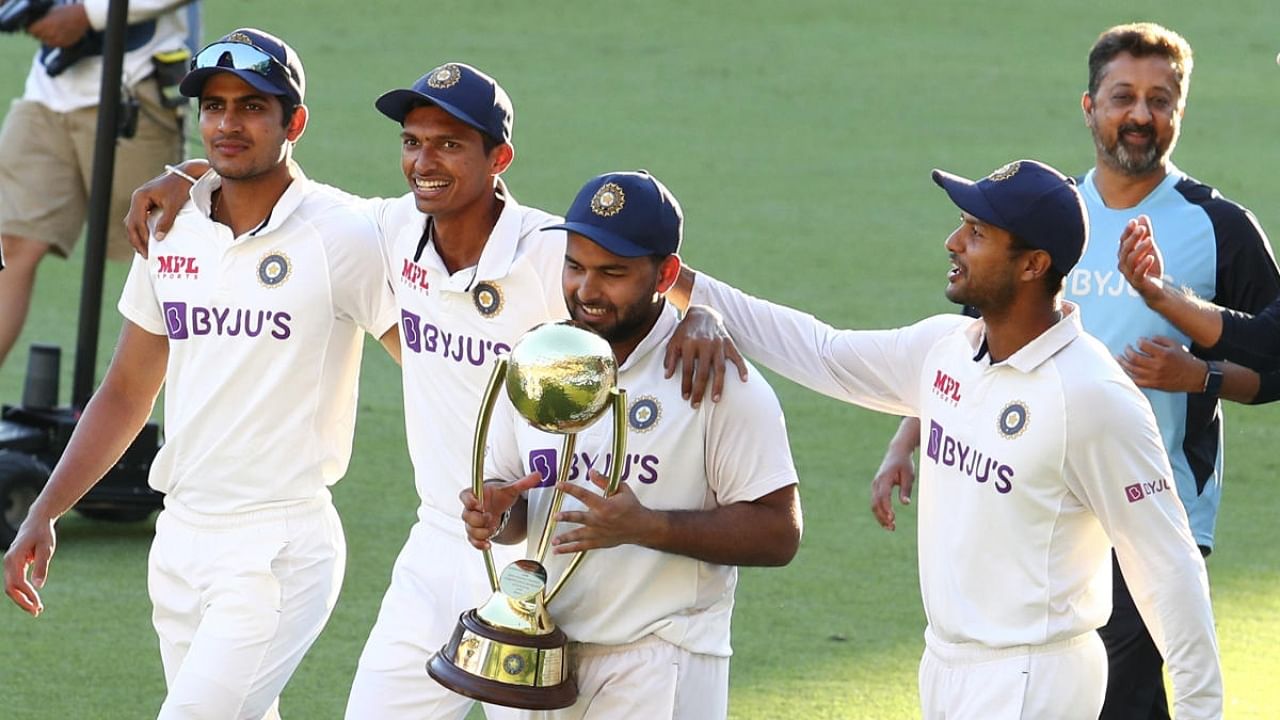 Rishabh Pant carries the trophy as he celebrates with his teammates after defeating Australia by three wickets on the final day of the fourth cricket test at the Gabba in 2021. Credit: PTI File Photo