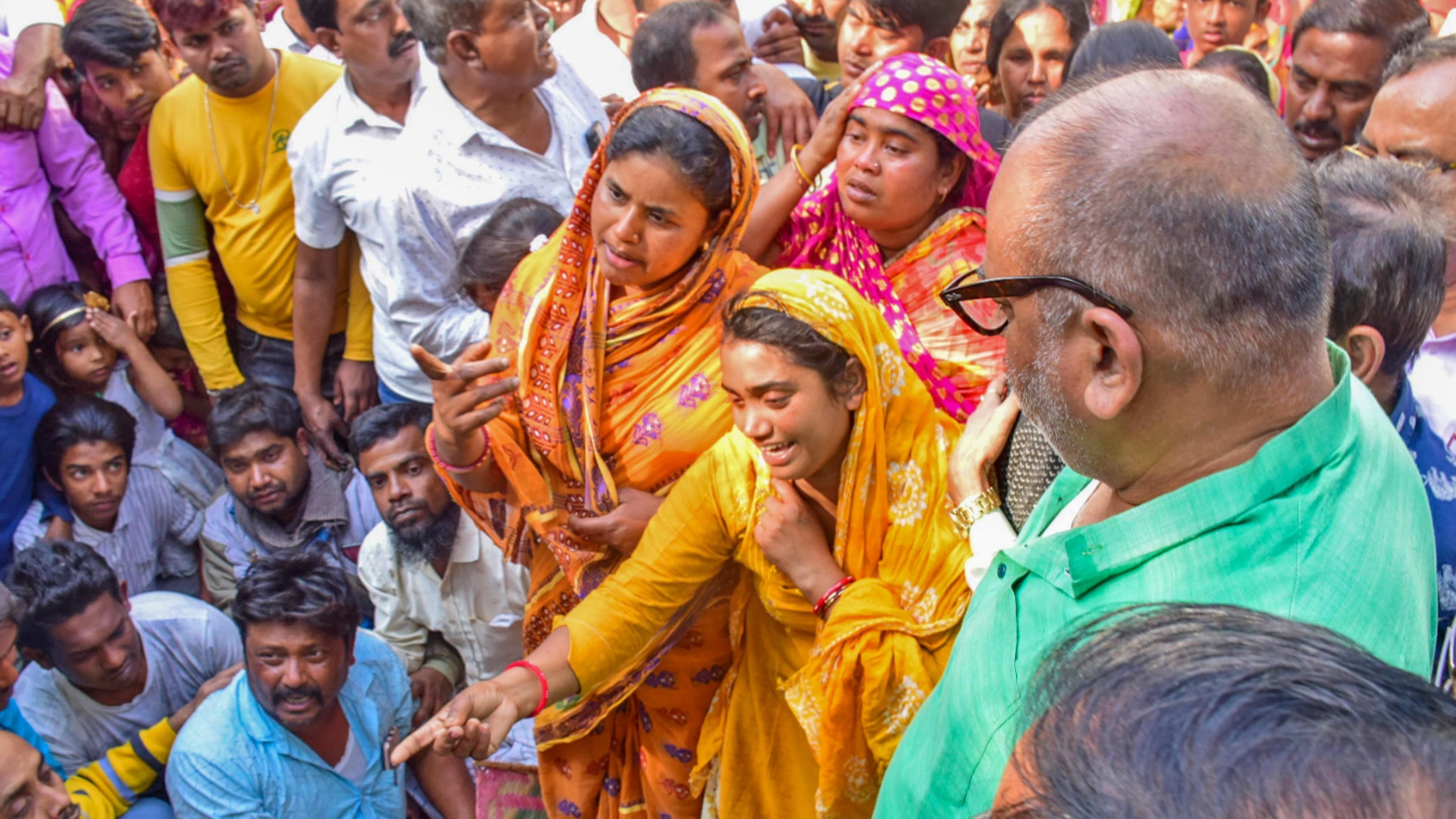 West Bengal Minister Chandranath Sinha meets the family members of Newton Seikh, a TMC member of Margram died when crud bombs were allegedly thrown at him, in Birbhum. Credit: PTI Photo