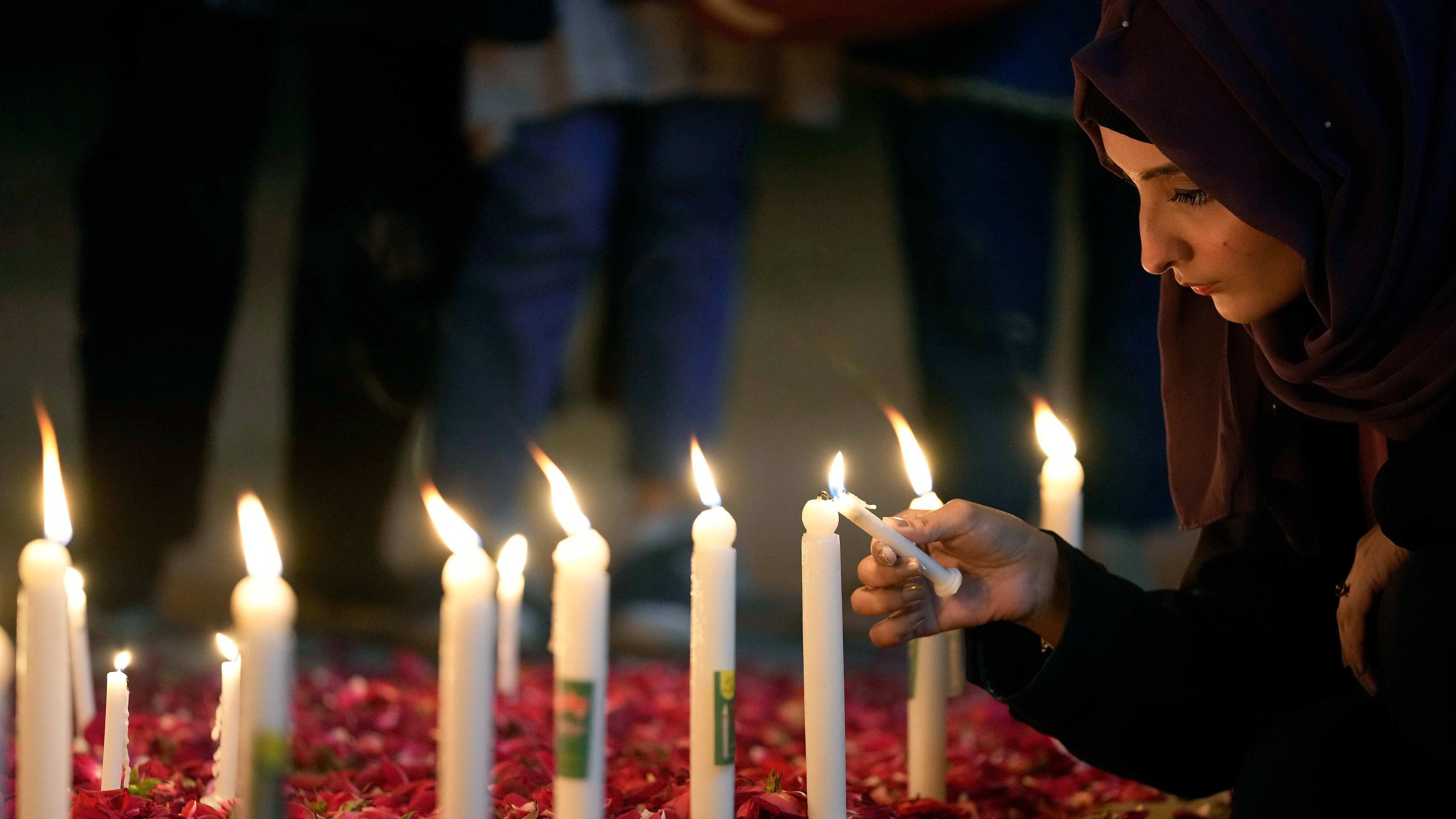 A woman light candles during a candle light vigil for the victims of earthquake in Syria and Turkey, in Islamabad, Pakistan, Monday, Feb. 6, 2023. A powerful 7.8 magnitude earthquake has rocked wide swaths of Turkey and Syria. It toppled hundreds of buildings and killed more than 1,900 people. Credit: AP Photo