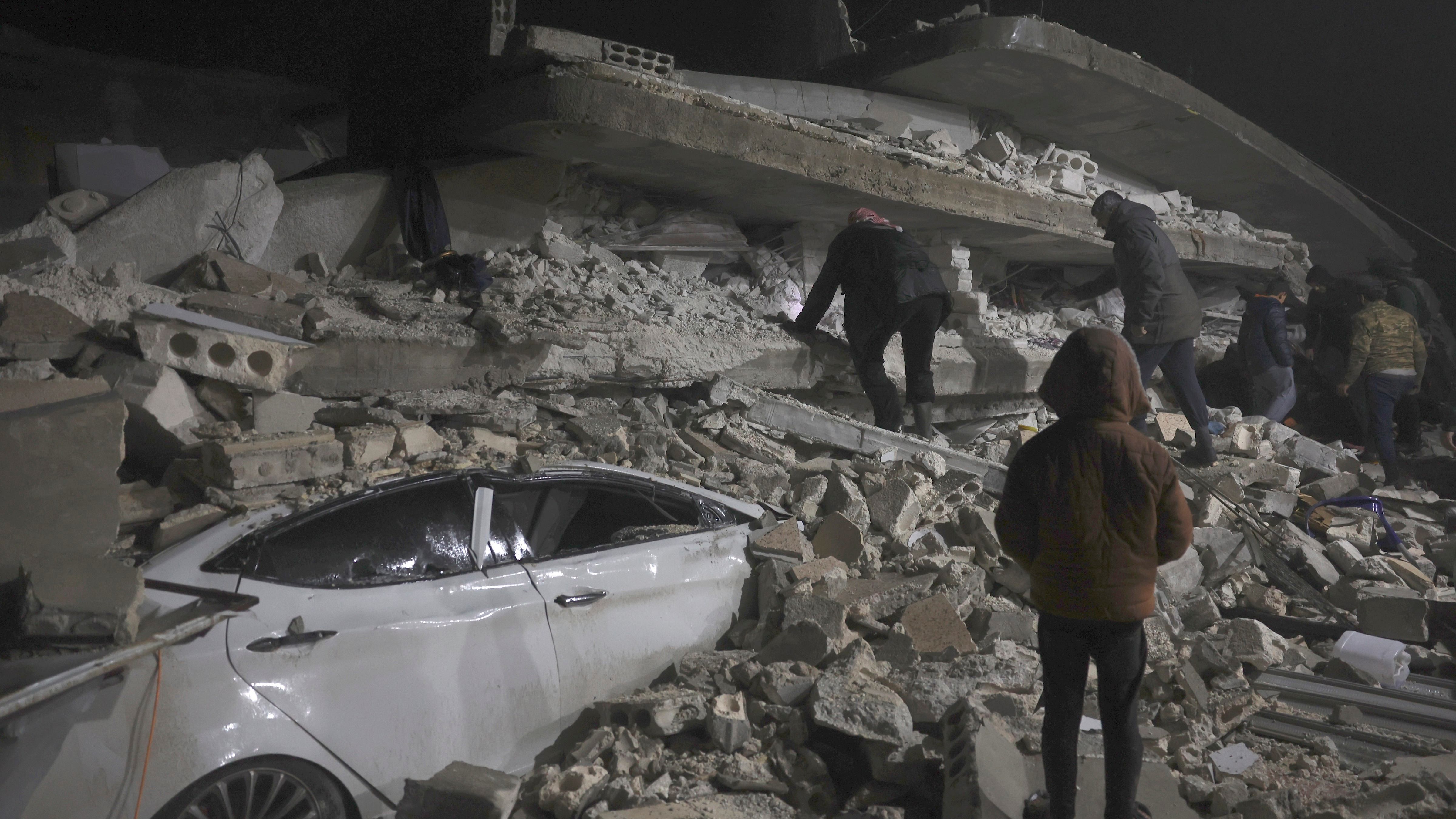 Syrian citizen search through the wreckage of a collapsed building, in Azmarin town, in Idlib province north Syria. Credit: AP Photo