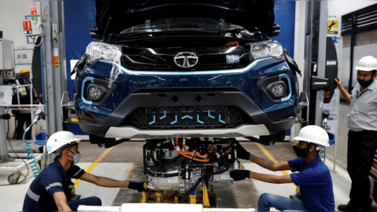 Workers install the electric motor inside a Tata Nexon electric sport utility vehicle (SUV) at the Tata Motors plant in Pune, Maharshtra on April 7, 2022. Credit: Reuters File Photo