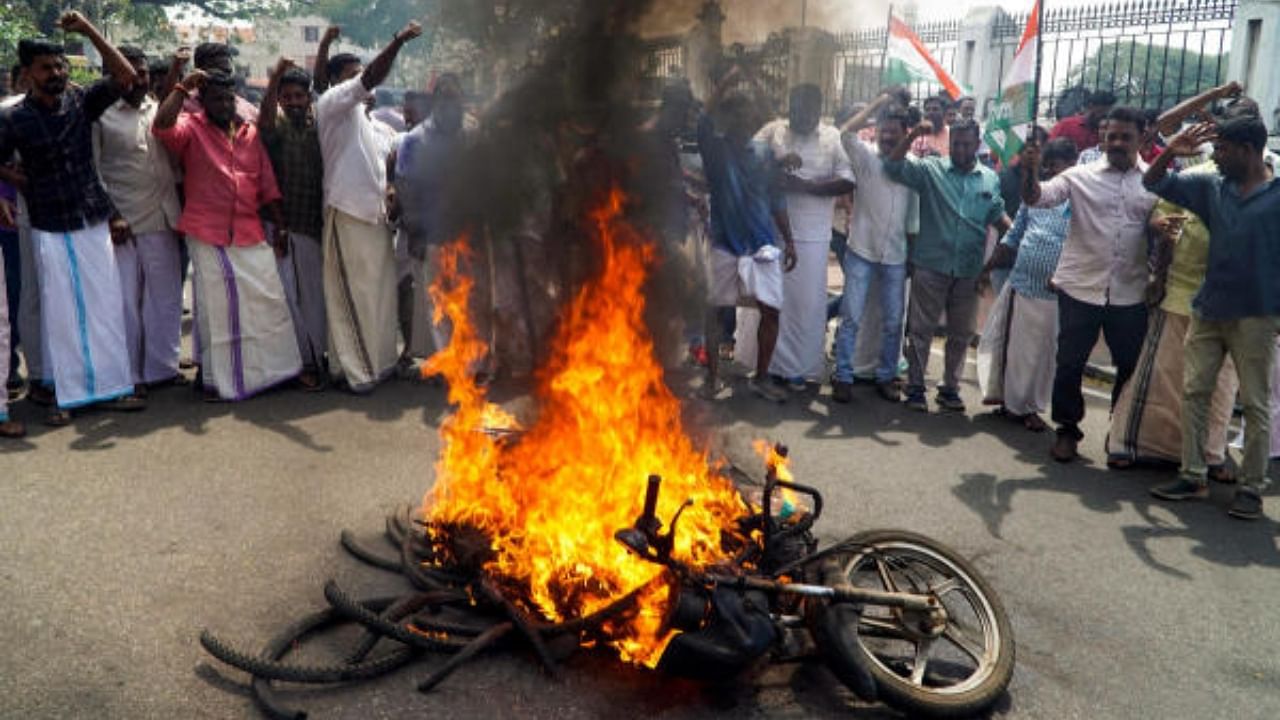 Youth Congress activists torch a bike during their protest march against the Kerala Budget. Credit: PTI Photo