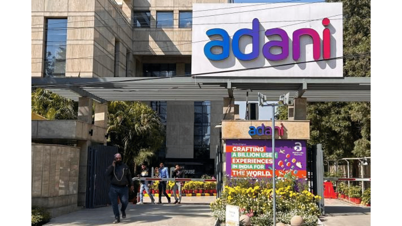 Employees walk past the Adani House corporate building at the institutional area in Gurugram. Credit: AFP Photo