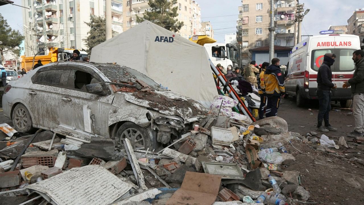 A damaged car is seen near the site of a collapsed building in the aftermath of a deadly earthquake in Diyarbakir, Turkey. Credit: Reuters Photo